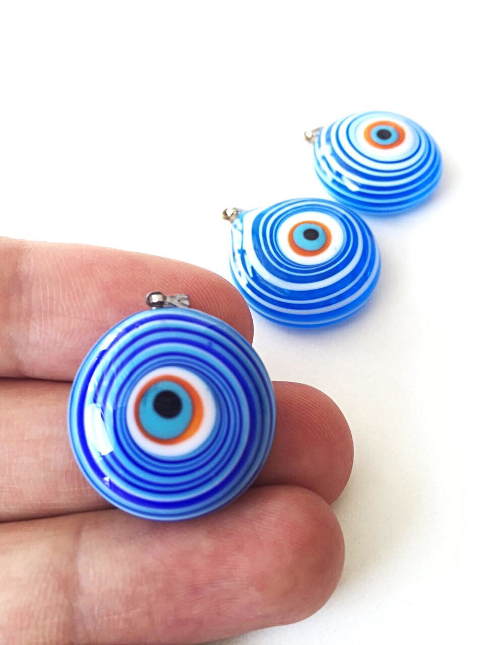 A stunning Murano glass evil eye pendant featuring a vibrant blue lampwork bead, symbolizing protection and good luck.