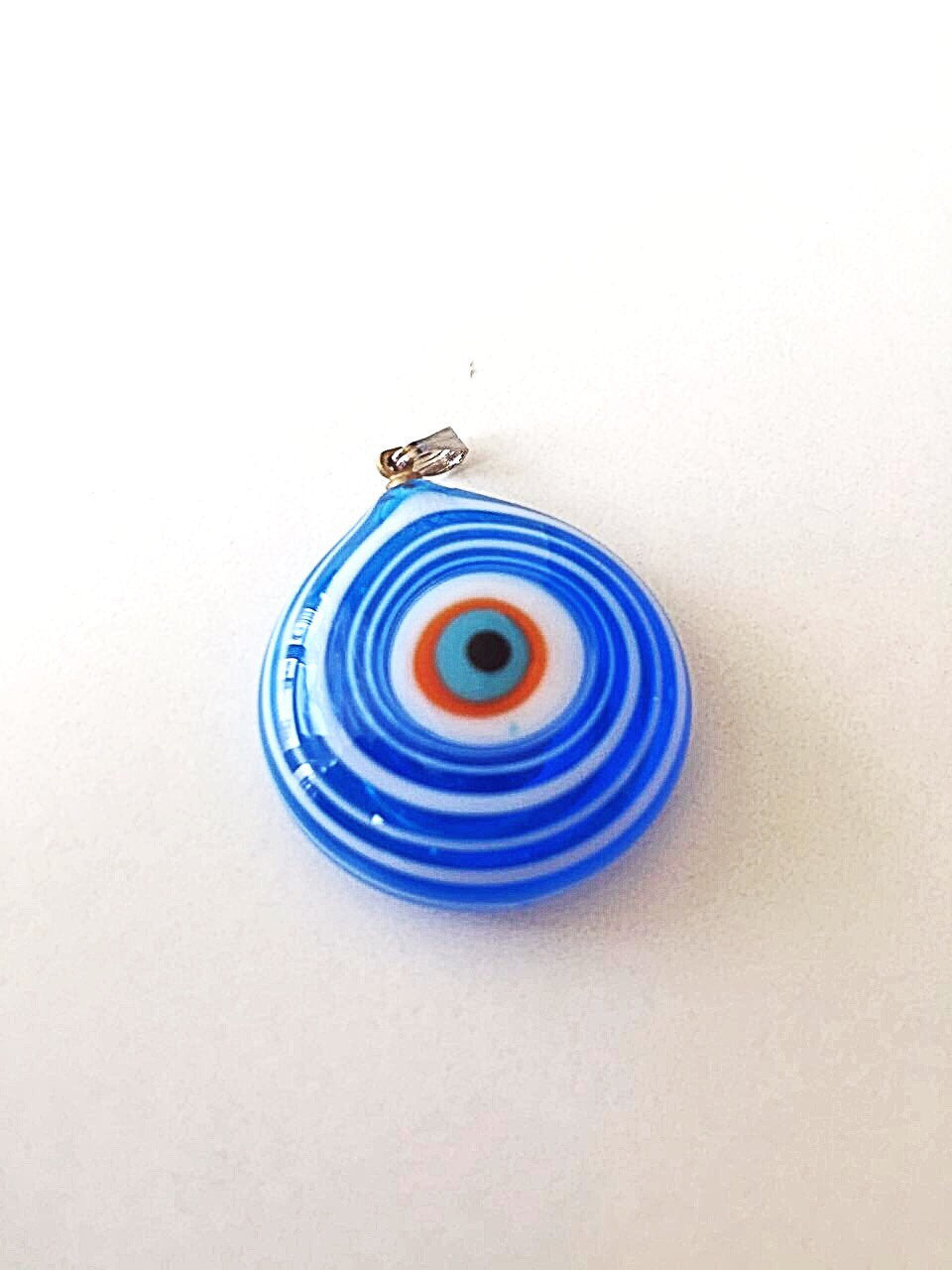 A stunning Murano glass evil eye pendant featuring a vibrant blue lampwork bead, symbolizing protection and good luck.