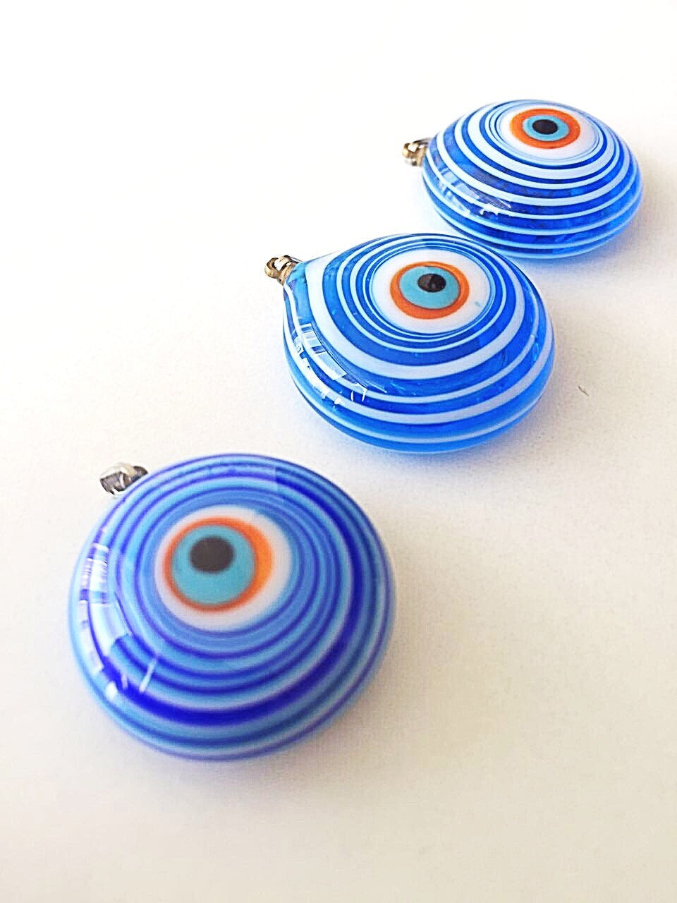 A stunning Murano glass evil eye pendant featuring a vibrant blue lampwork bead, symbolizing protection and good luck.