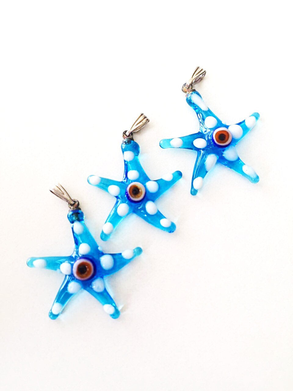 Murano glass evil eye starfish pendant in blue, showcasing intricate lampwork design and vibrant colors.