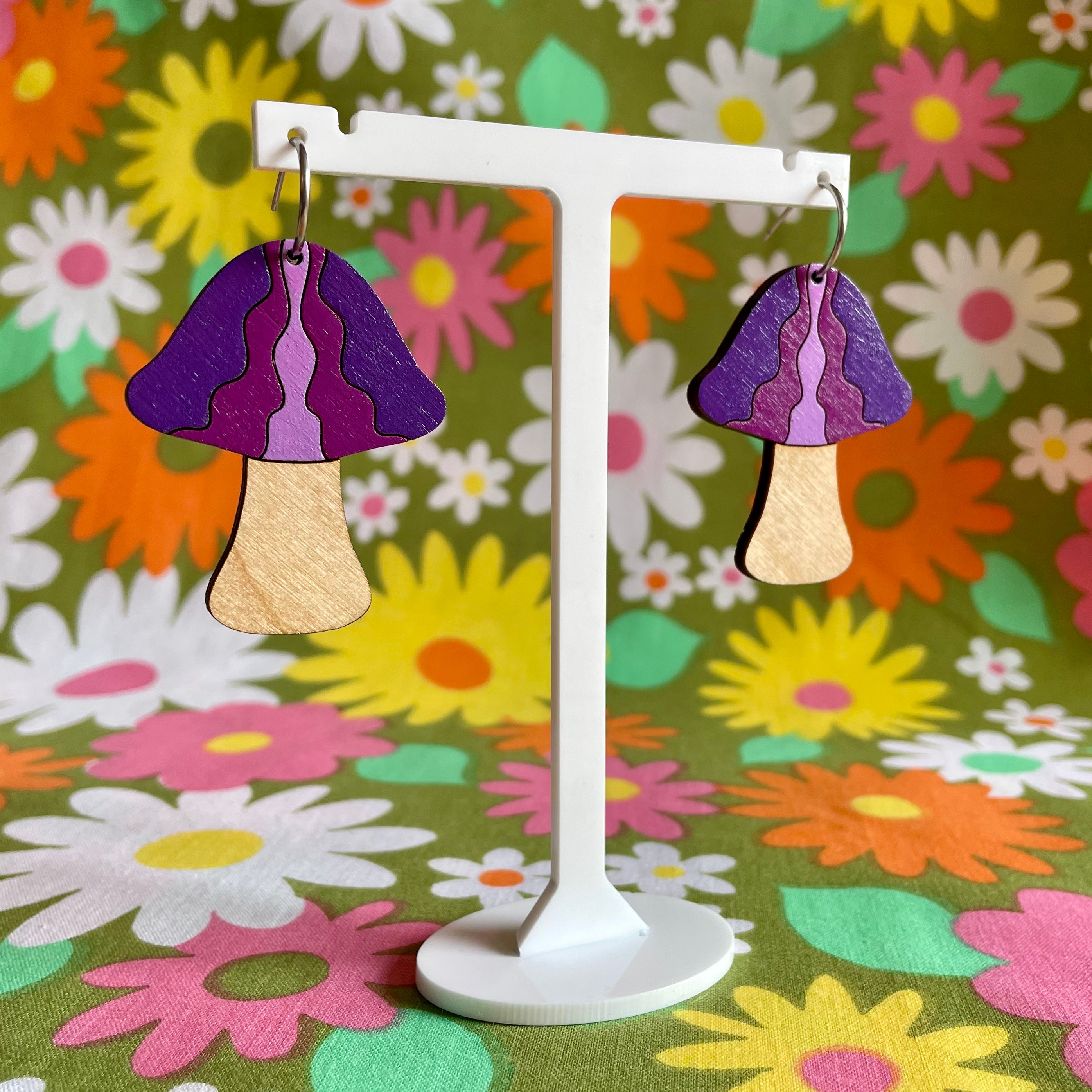 A pair of handcrafted wooden mushroom earrings in waves design, made from sustainable Birch Plywood, showcasing vibrant colors and intricate details.