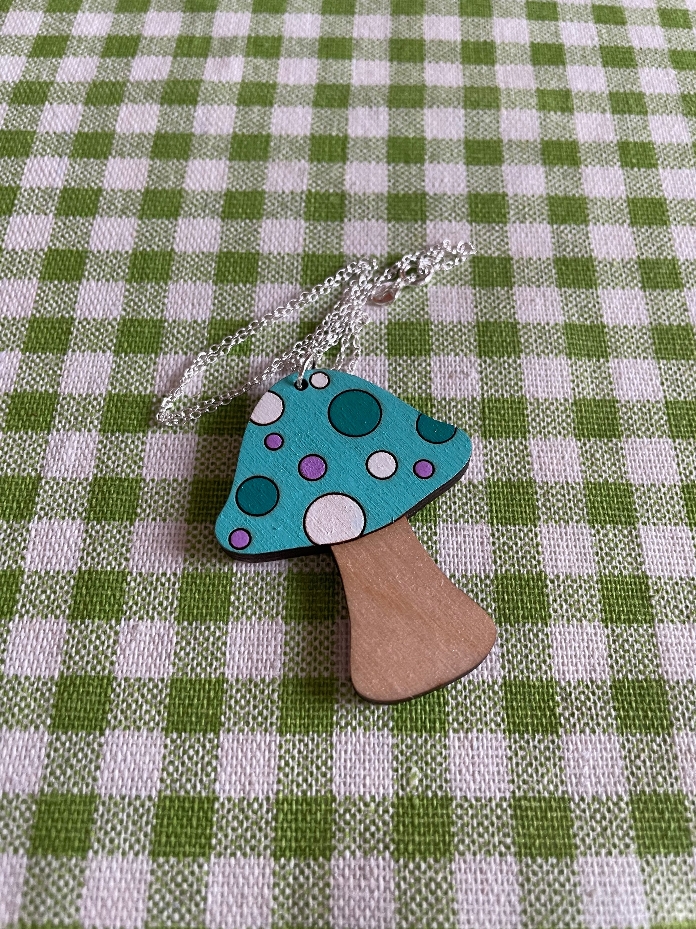 A handcrafted wooden mushroom necklace featuring spots, made from sustainable Birch Plywood, showcasing a unique vintage-inspired design.