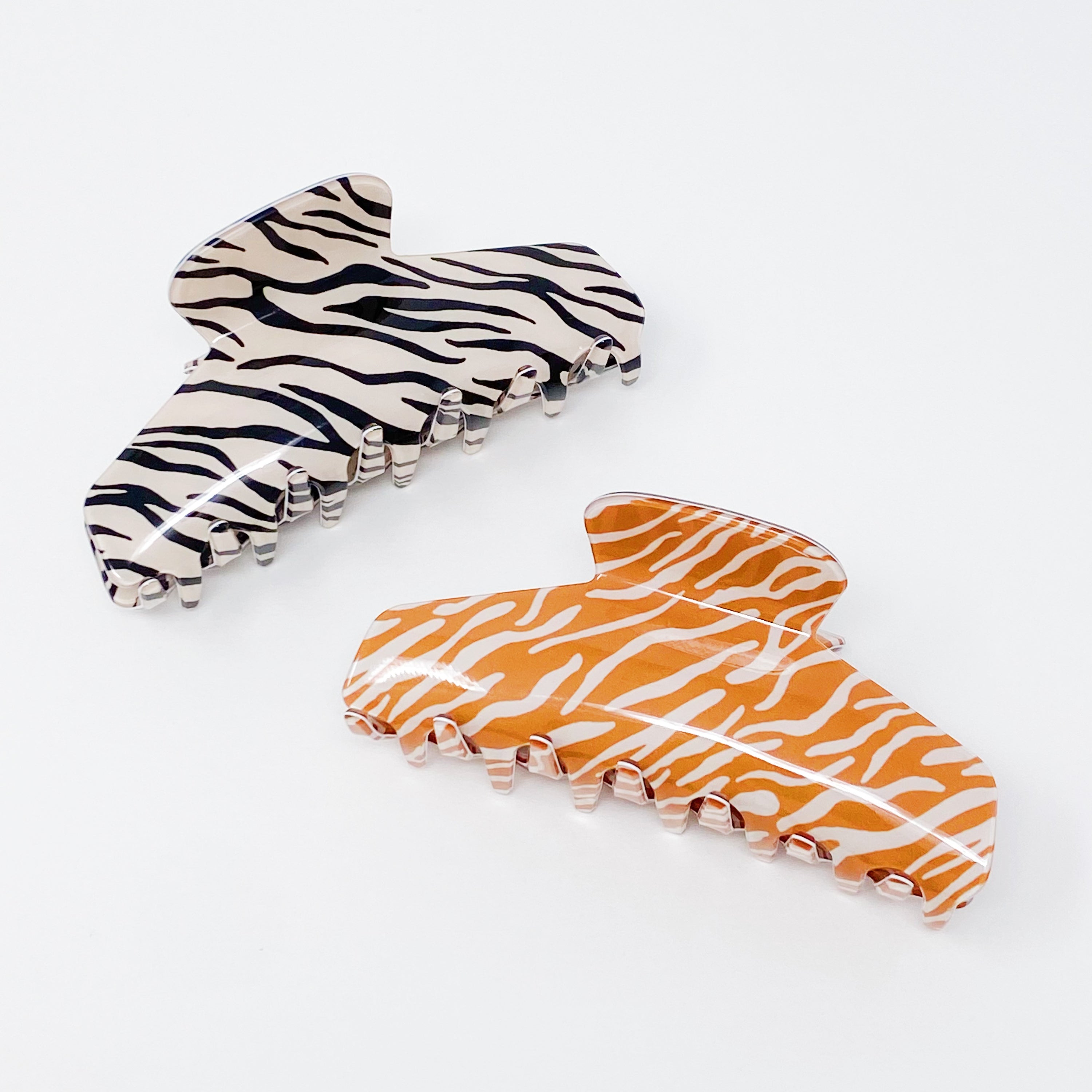 Muted zebra print hair claw clip made of durable acrylic, designed to hold thick hair securely with a stylish aesthetic.