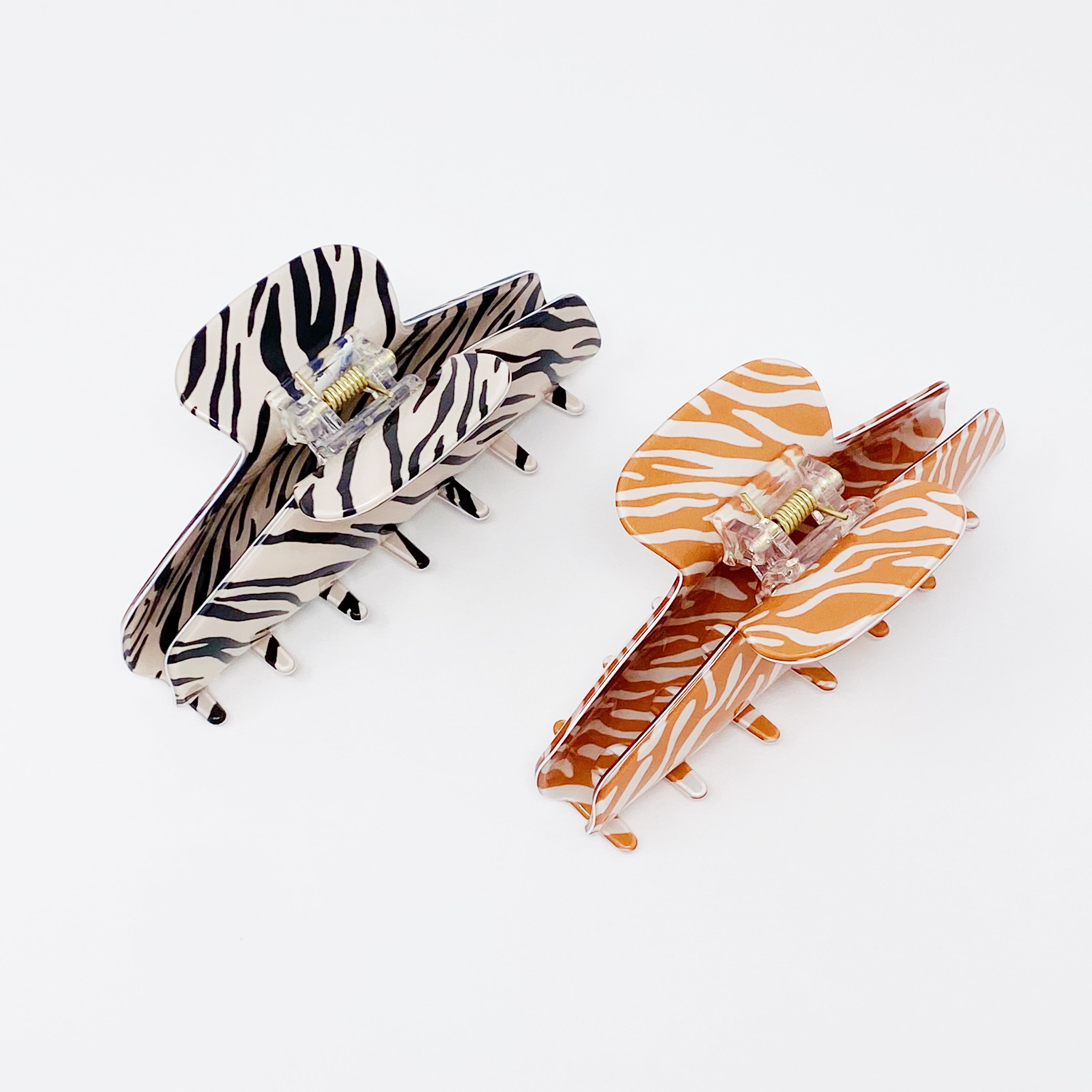 Muted zebra print hair claw clip made of durable acrylic, designed to hold thick hair securely with a stylish aesthetic.