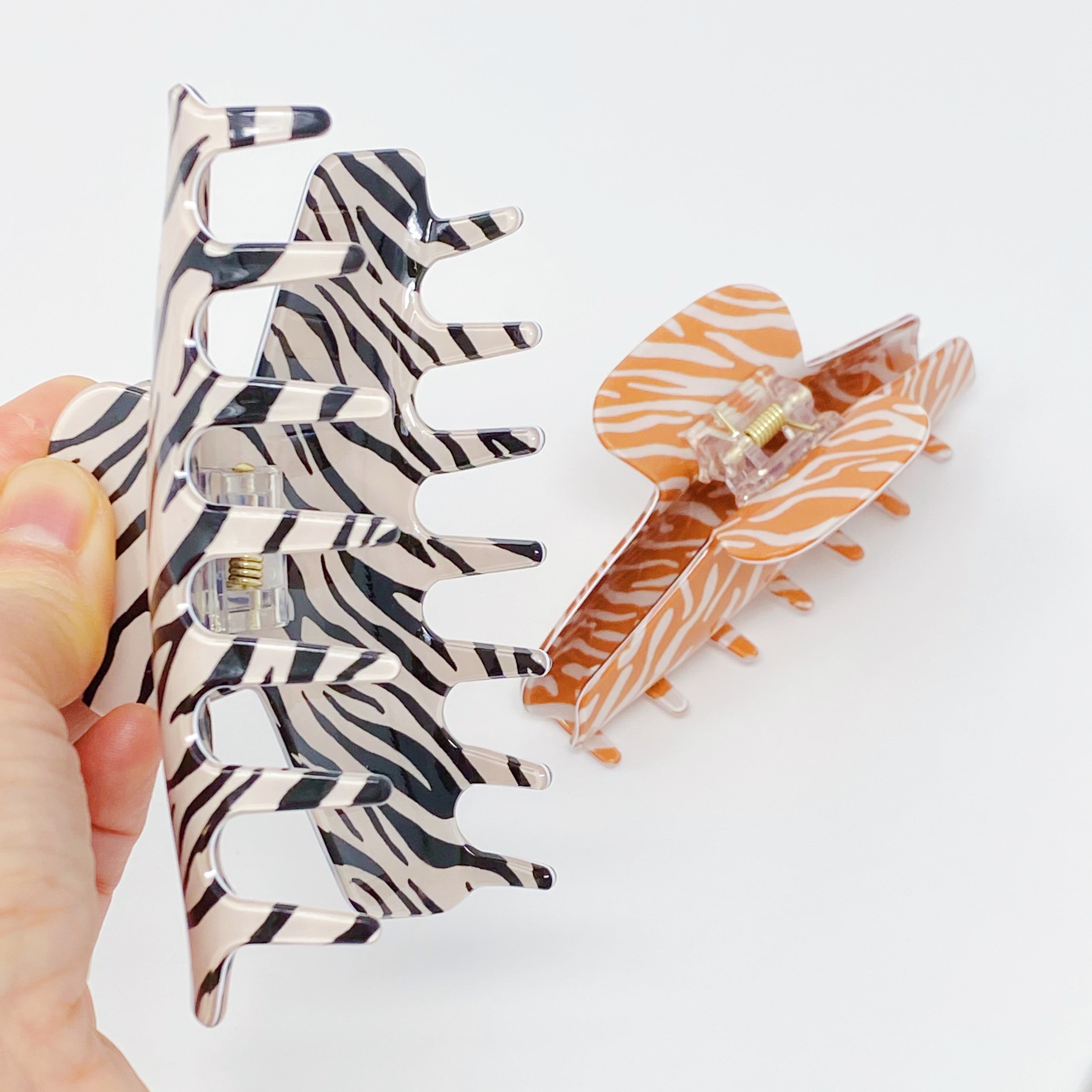 Muted zebra print hair claw clip made of durable acrylic, designed to hold thick hair securely with a stylish aesthetic.