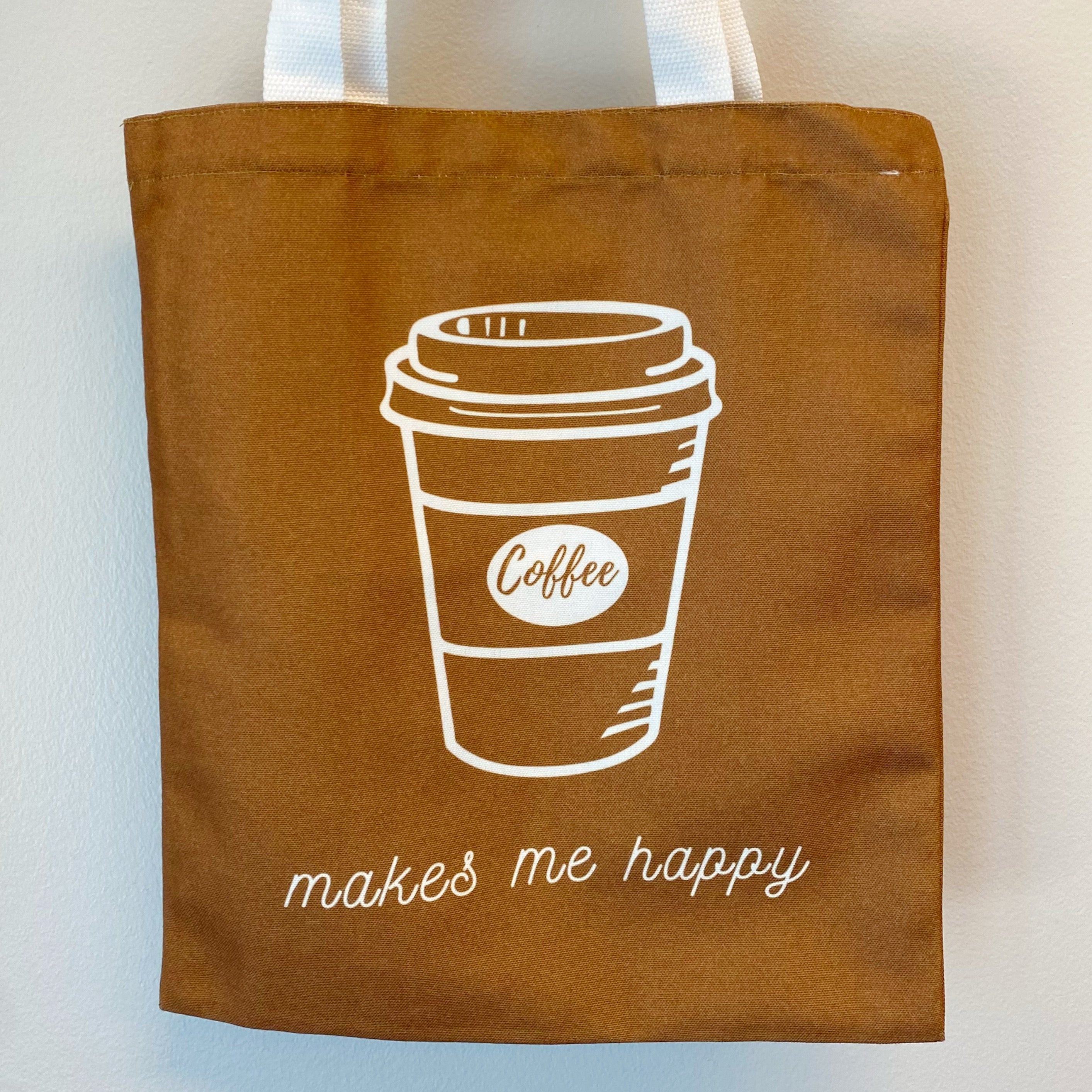 A stylish My Happy Canvas Tote featuring a positive graphic print, perfect for carrying books and small devices.