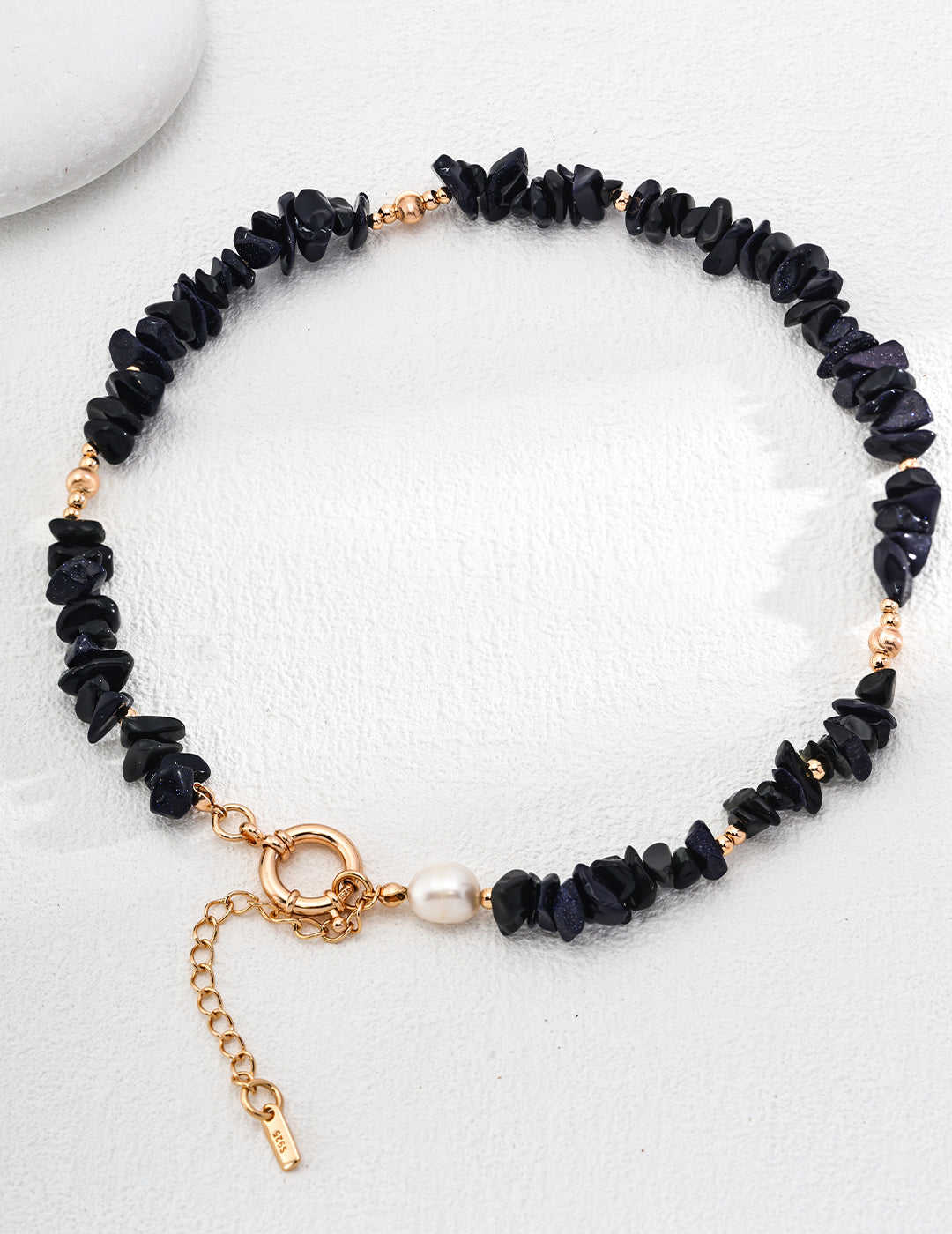 A stunning Mystical Blue Sandstone Necklace adorned with natural pearls, showcasing a deep blue color with shimmering specks resembling a starry night.