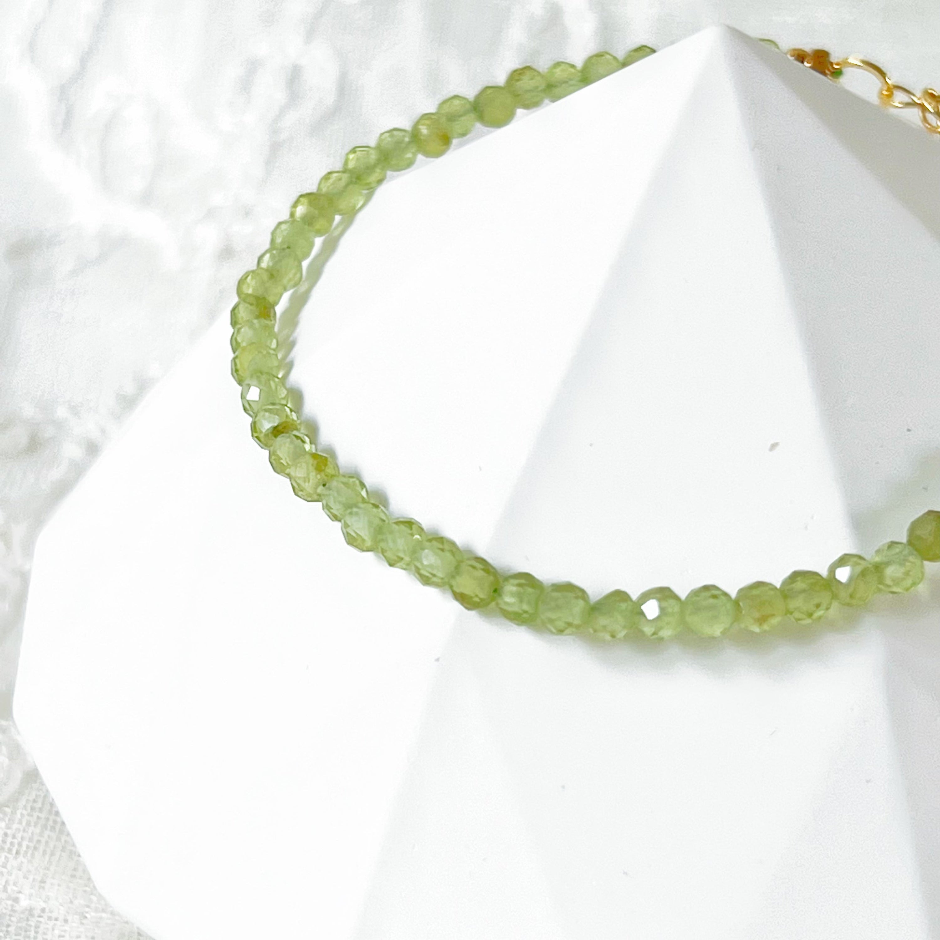 Natural Green Peridot Beaded Bracelet featuring 2-3mm peridot beads with gold plated bronze buckle and chain, elegantly displayed in a gift box.