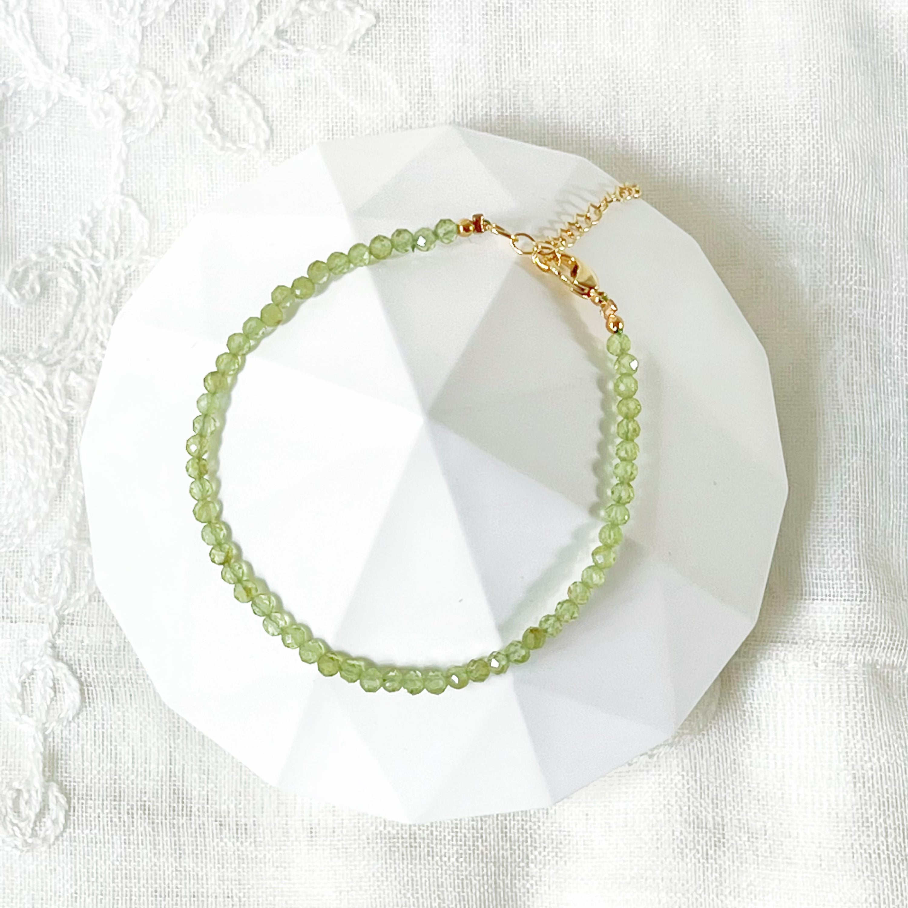 Natural Green Peridot Beaded Bracelet featuring 2-3mm peridot beads with gold plated bronze buckle and chain, elegantly displayed in a gift box.