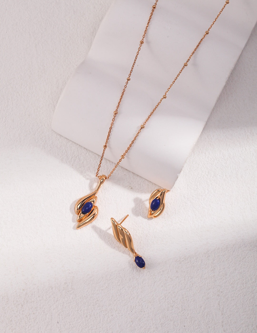 Handmade natural lapis lazuli asymmetrical earrings with gold vermeil, showcasing unique blue stones and elegant design.