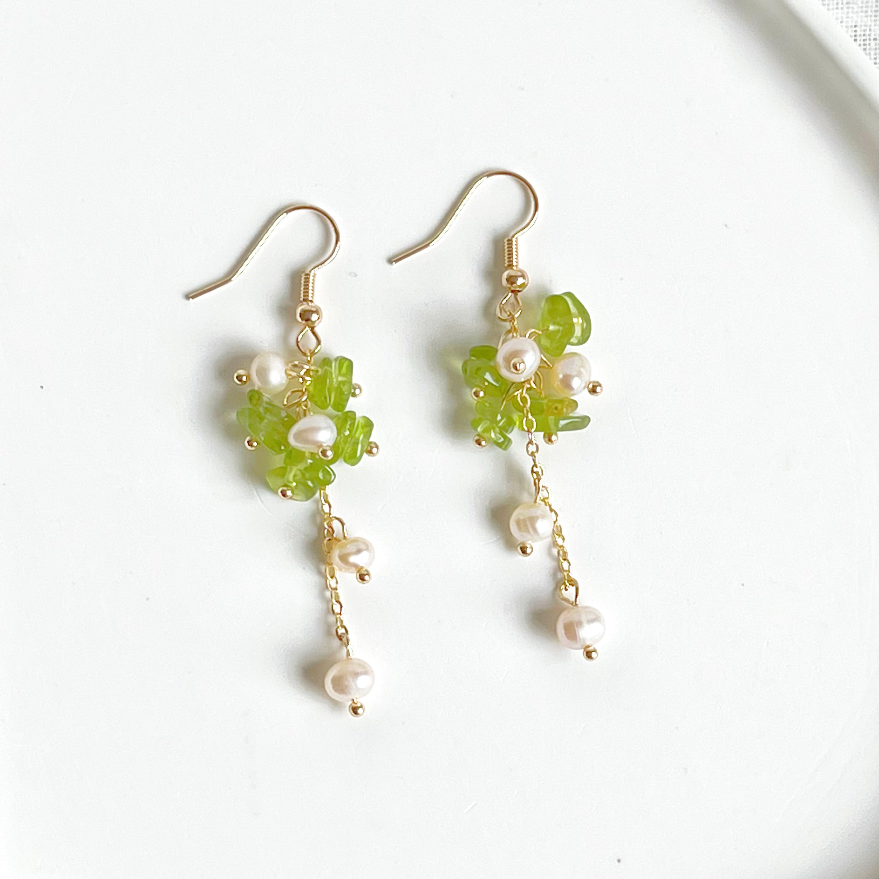 Natural peridot and pearl drop earrings featuring sterling silver ear wire, showcasing unique green gemstones and baroque freshwater pearls.