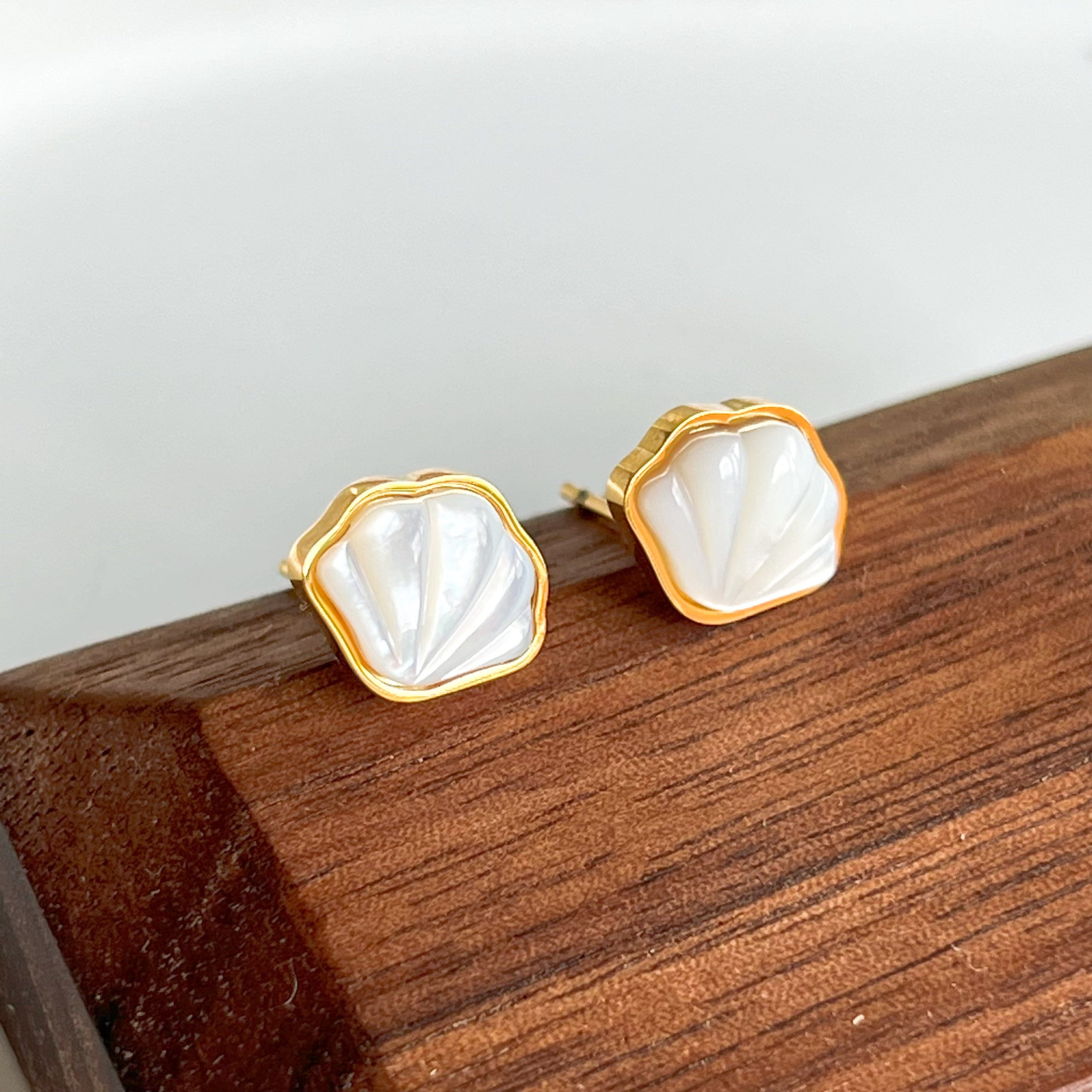 Natural seashell stud earrings featuring sterling silver and gold plated bronze accents, with mini freshwater pearls.