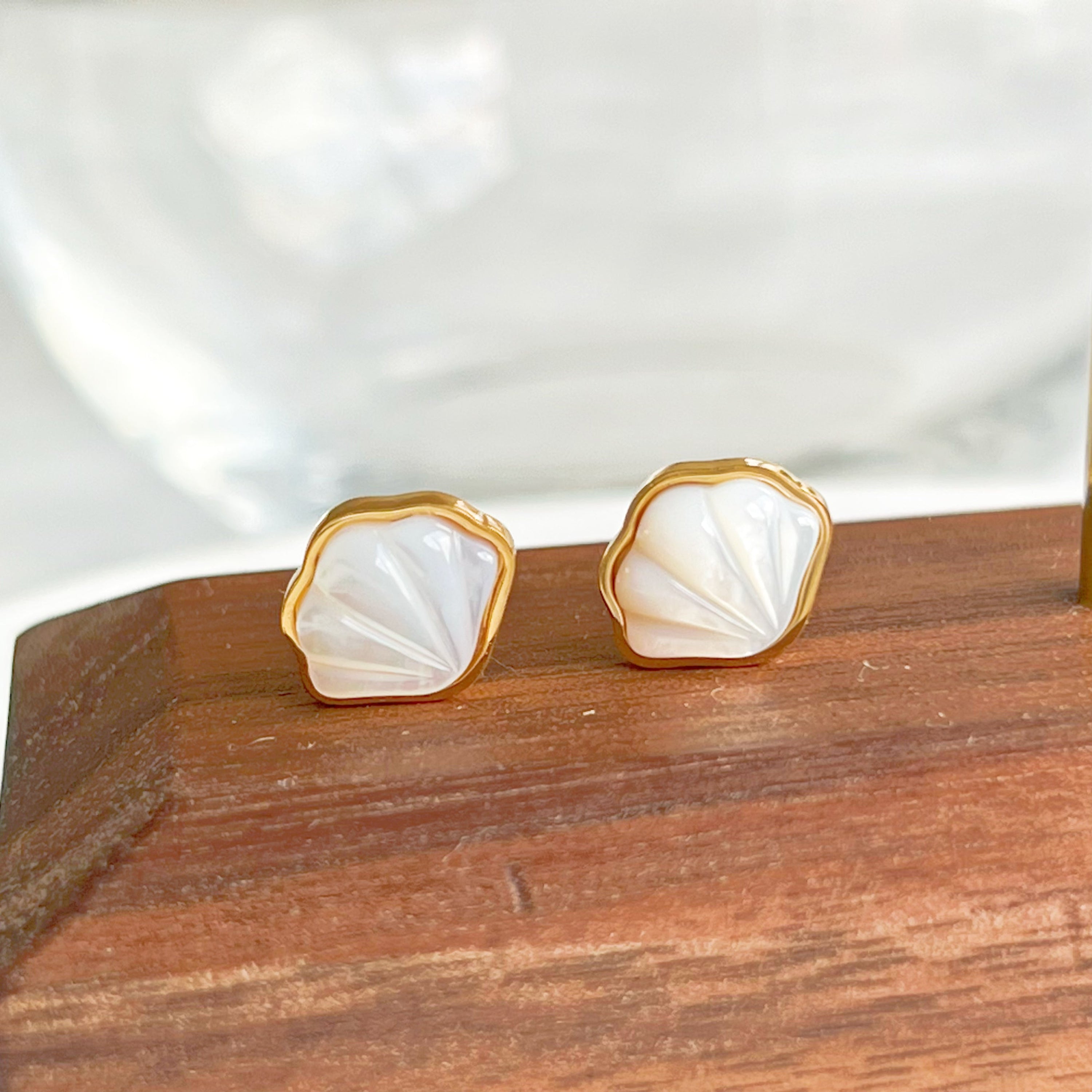 Natural seashell stud earrings featuring sterling silver and gold plated bronze accents, with mini freshwater pearls.