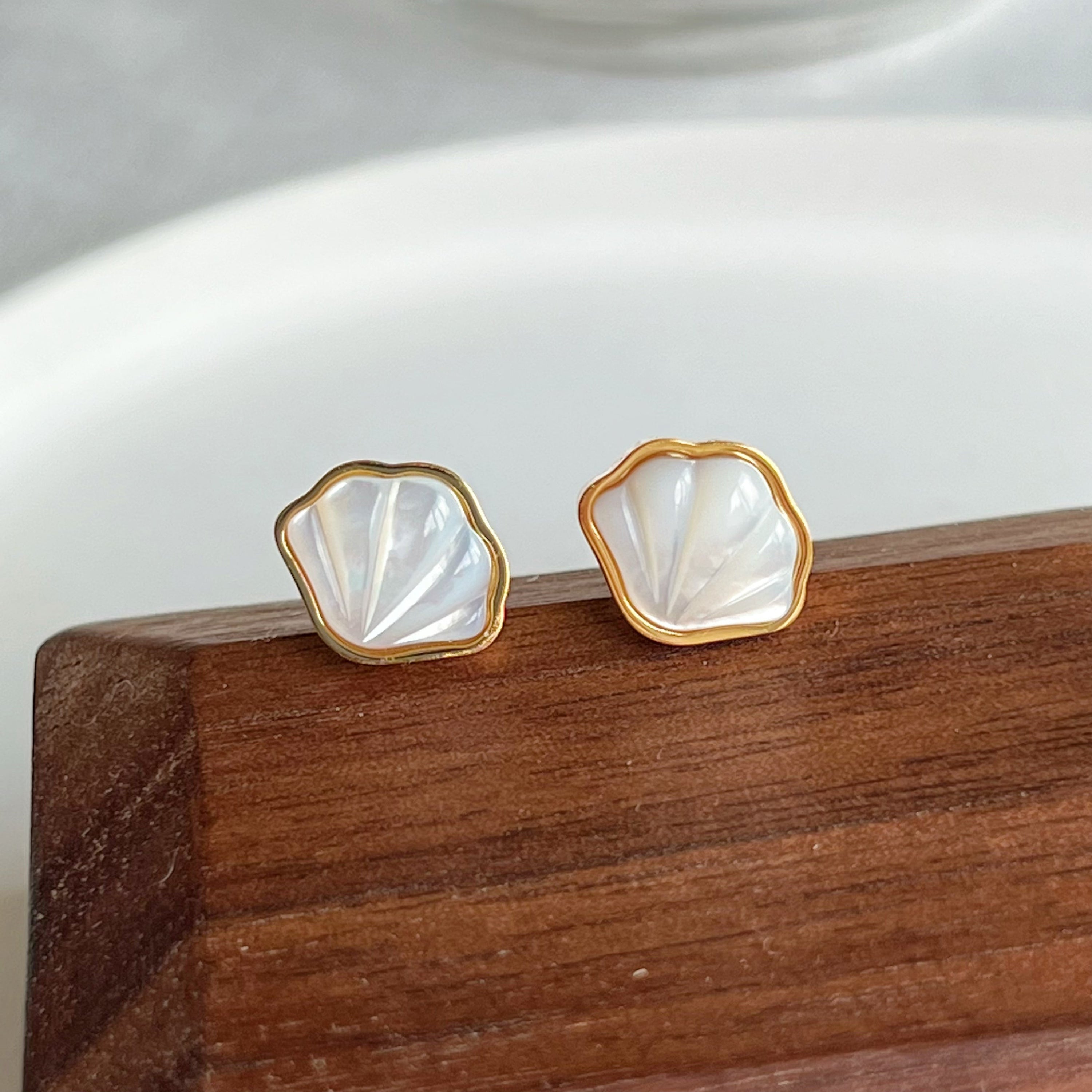 Natural seashell stud earrings featuring sterling silver and gold plated bronze accents, with mini freshwater pearls.