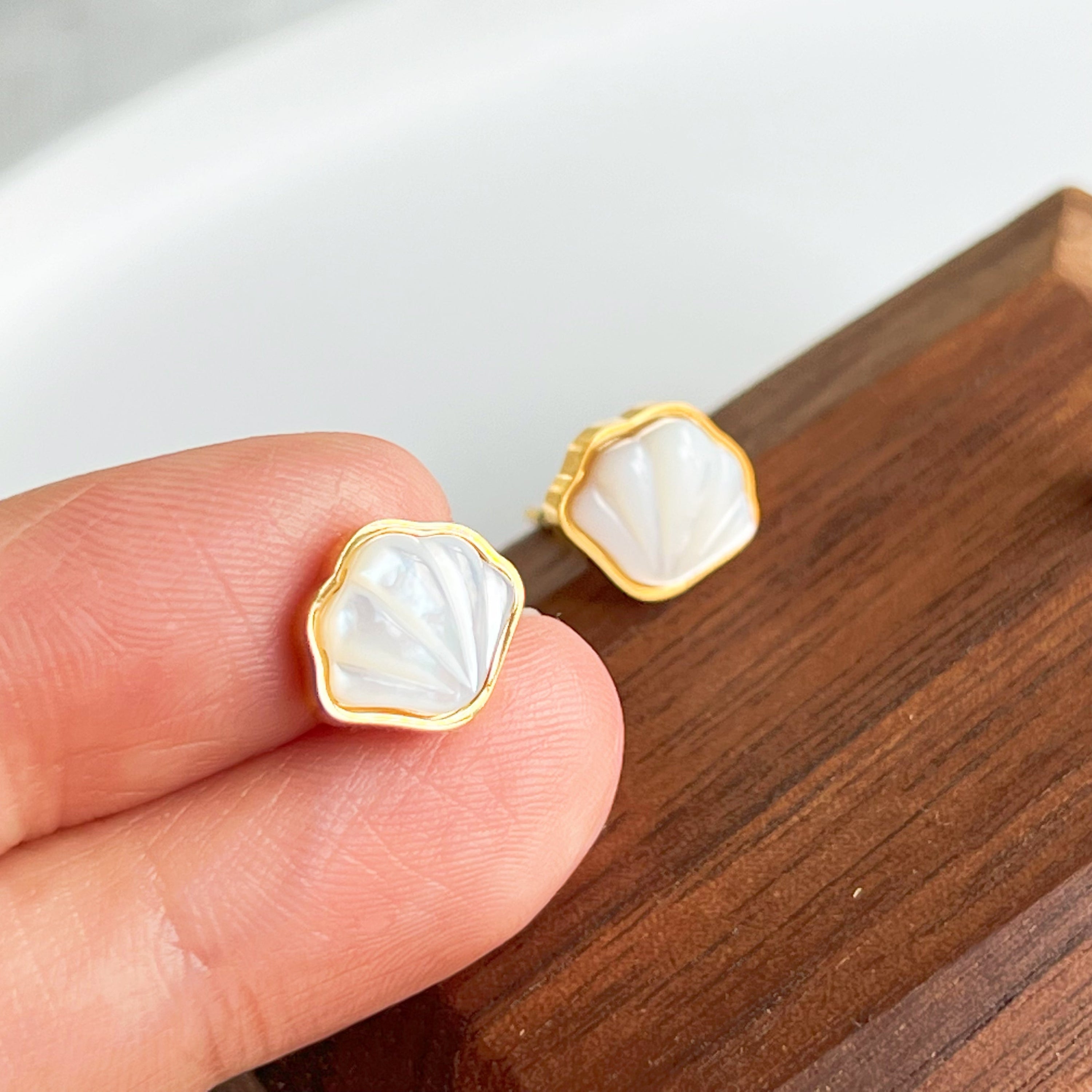 Natural seashell stud earrings featuring sterling silver and gold plated bronze accents, with mini freshwater pearls.