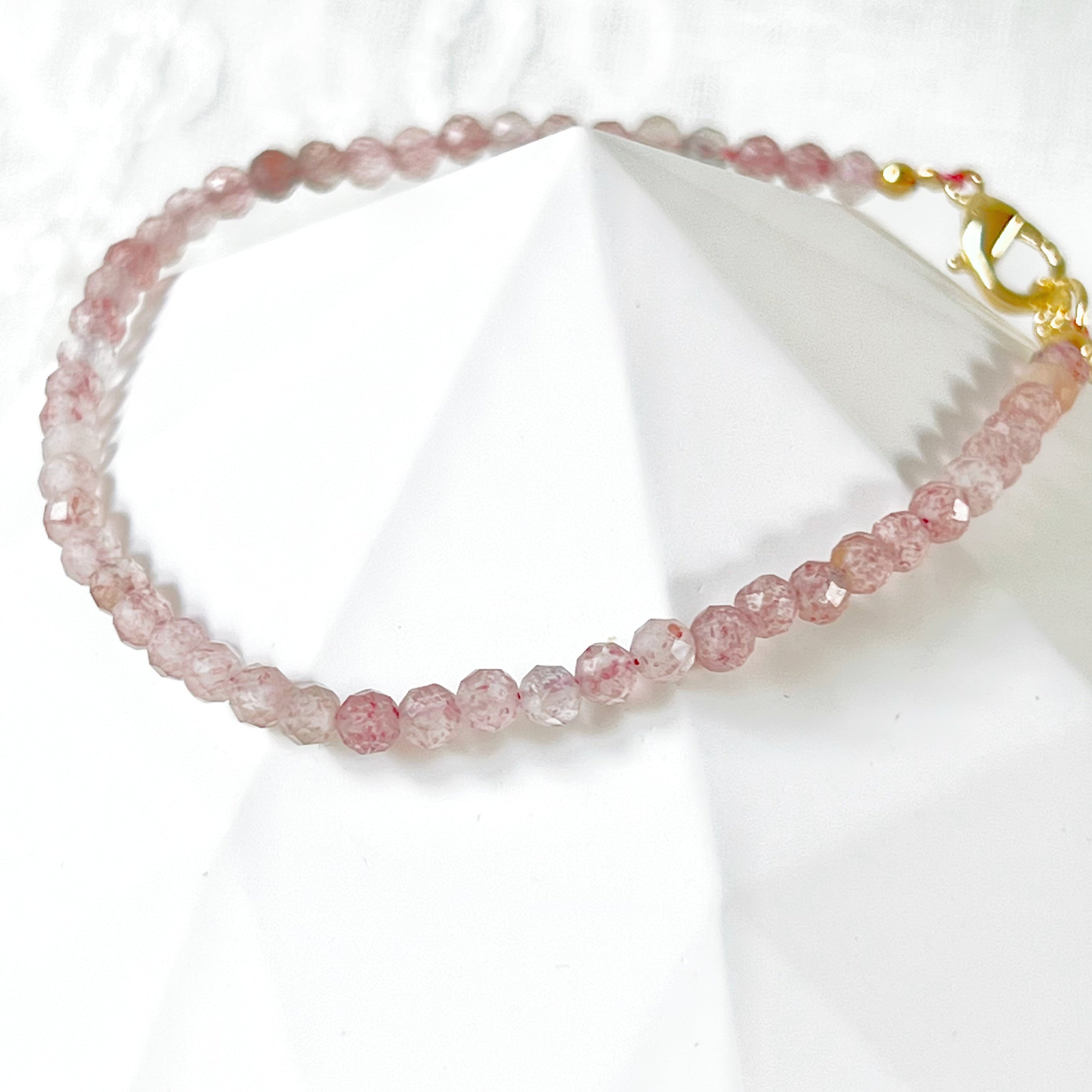 Natural Strawberry Quartz Beaded Bracelet with gold plated bronze buckle, showcasing unique pink beads.