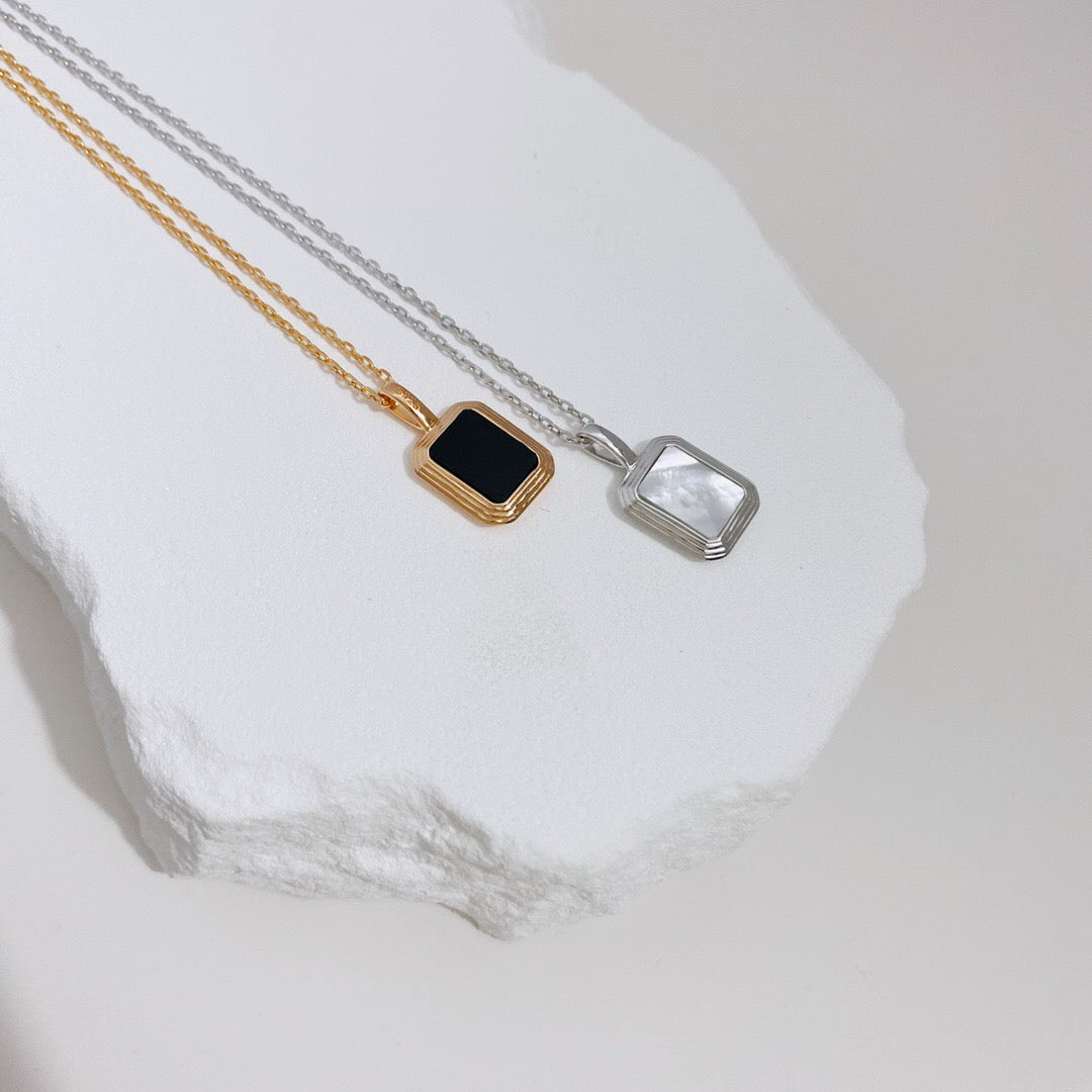 Natural White Shell and Black Onyx Pendant Necklace featuring gold vermeil chain, showcasing a unique handmade design.