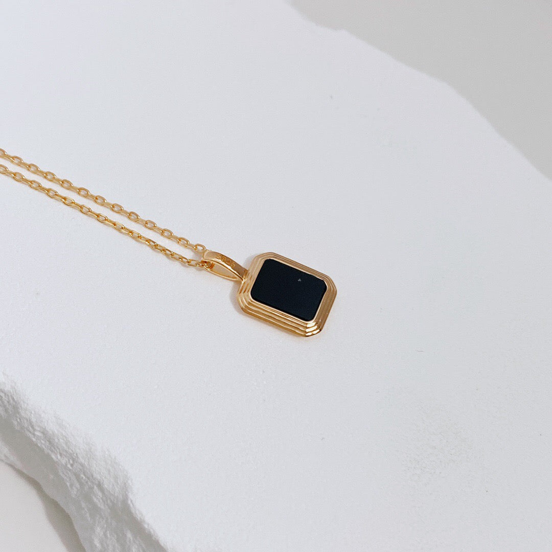 Natural White Shell and Black Onyx Pendant Necklace featuring gold vermeil chain, showcasing a unique handmade design.