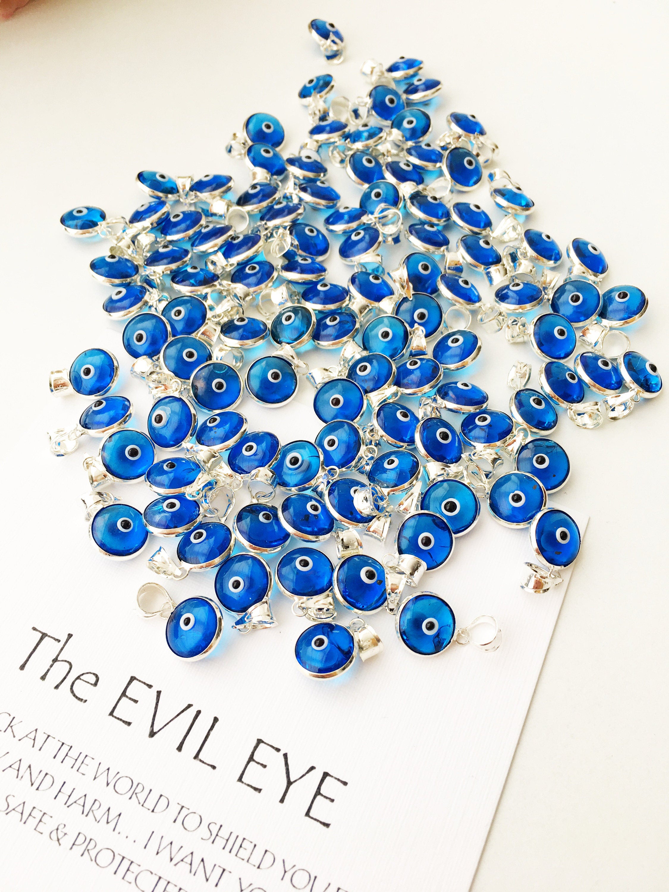 Navy blue evil eye charm featuring a tiny glass bead and silver-plated brass pendant, symbolizing protection and good luck.