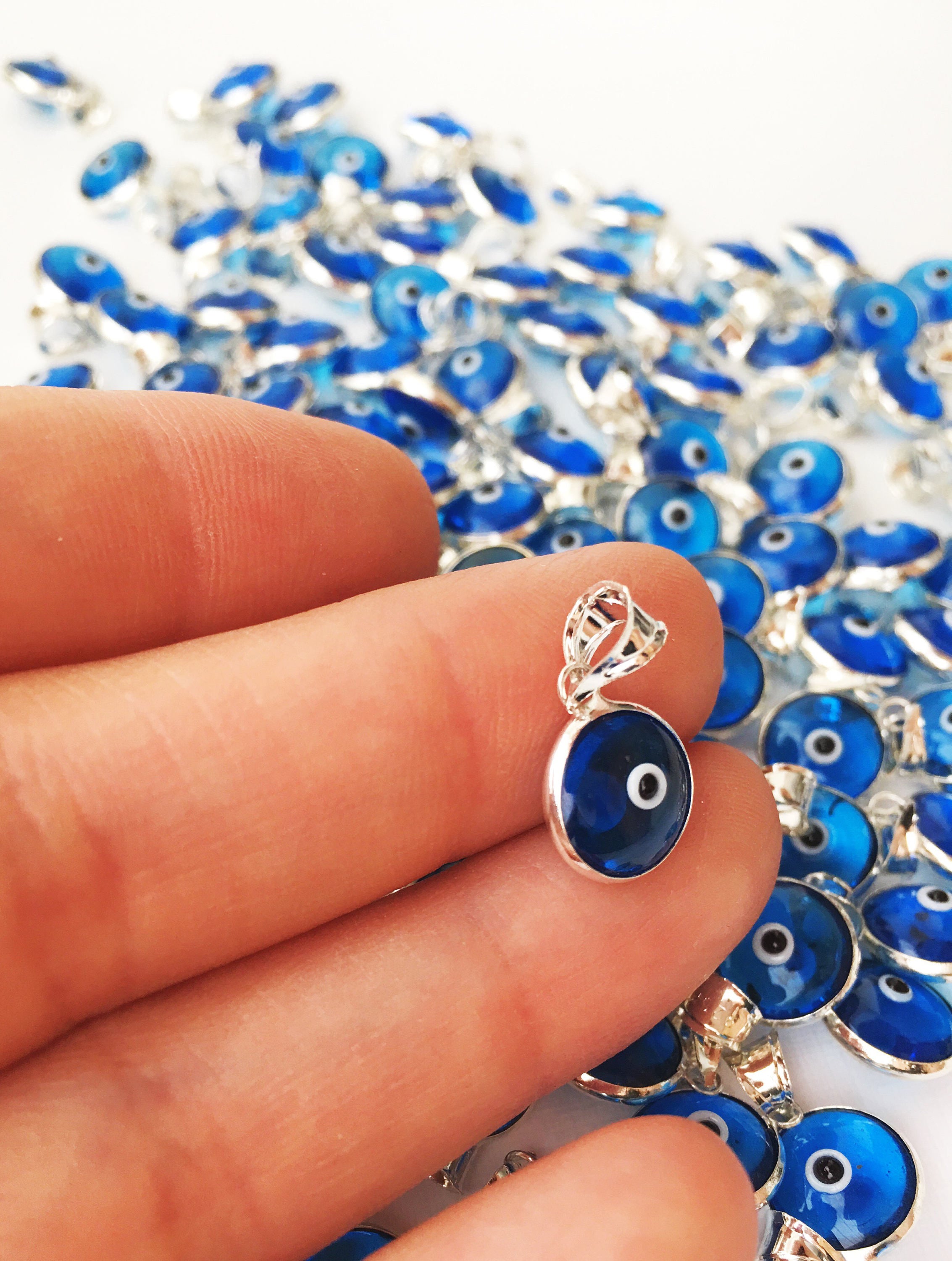 Navy blue evil eye charm featuring a tiny glass bead and silver-plated brass pendant, symbolizing protection and good luck.