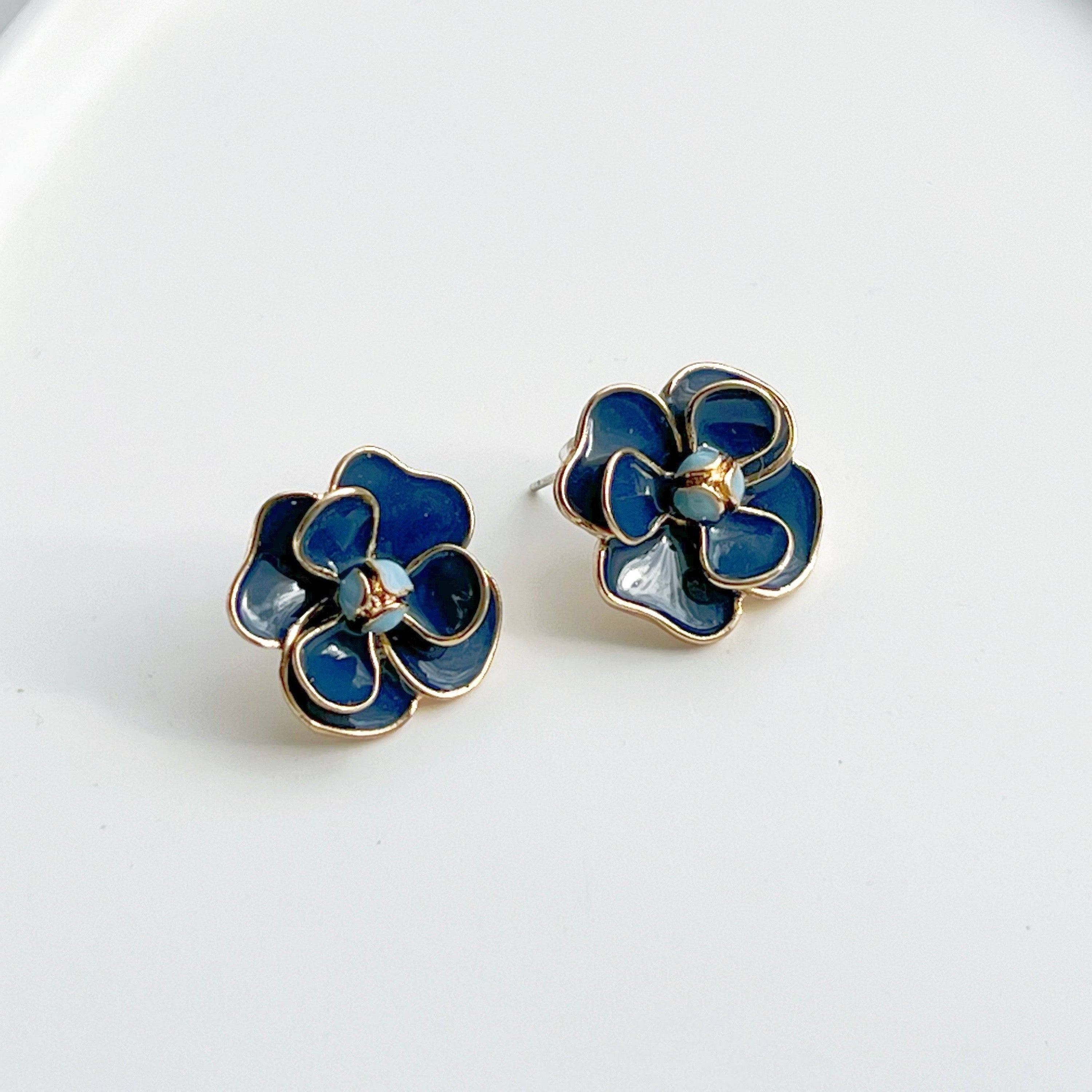 Navy blue rose earrings in flower shape, crafted from sterling silver and gold-plated bronze, displayed elegantly in a gift box.