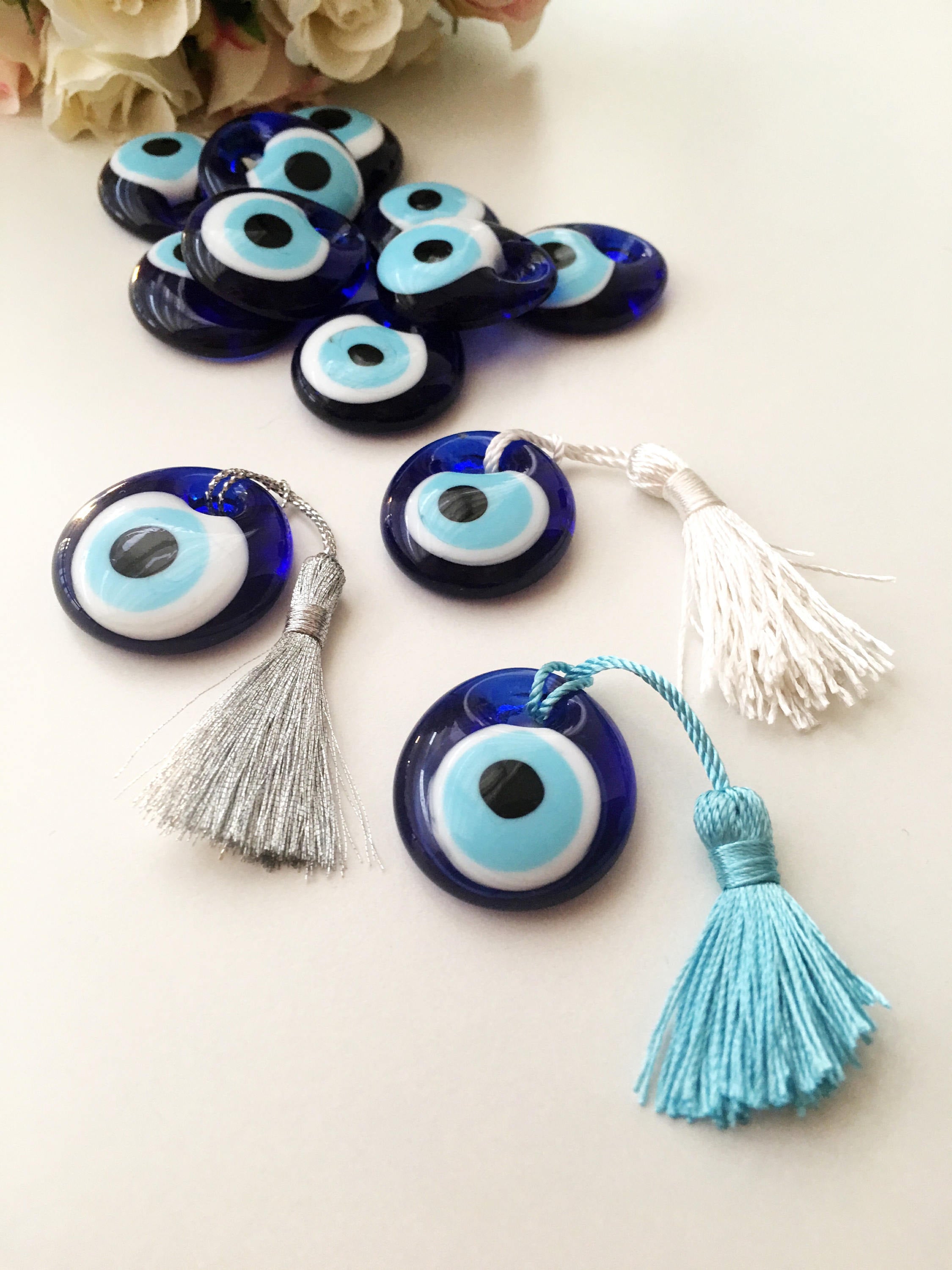 A collection of 50 blue glass evil eye beads with tassels, symbolizing protection and good luck, perfect for wedding favors.