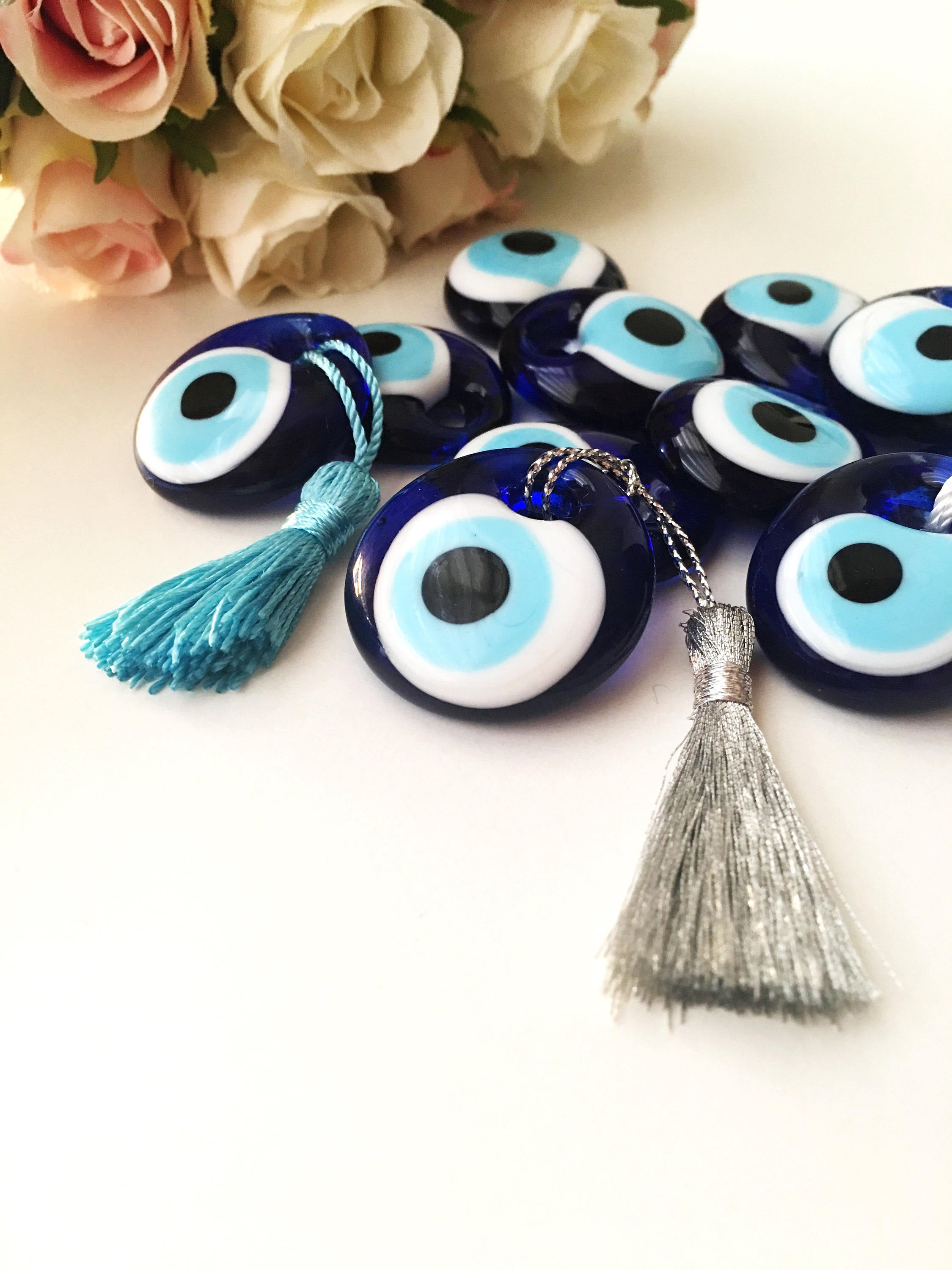 A collection of 50 blue glass evil eye beads with tassels, symbolizing protection and good luck, perfect for wedding favors.