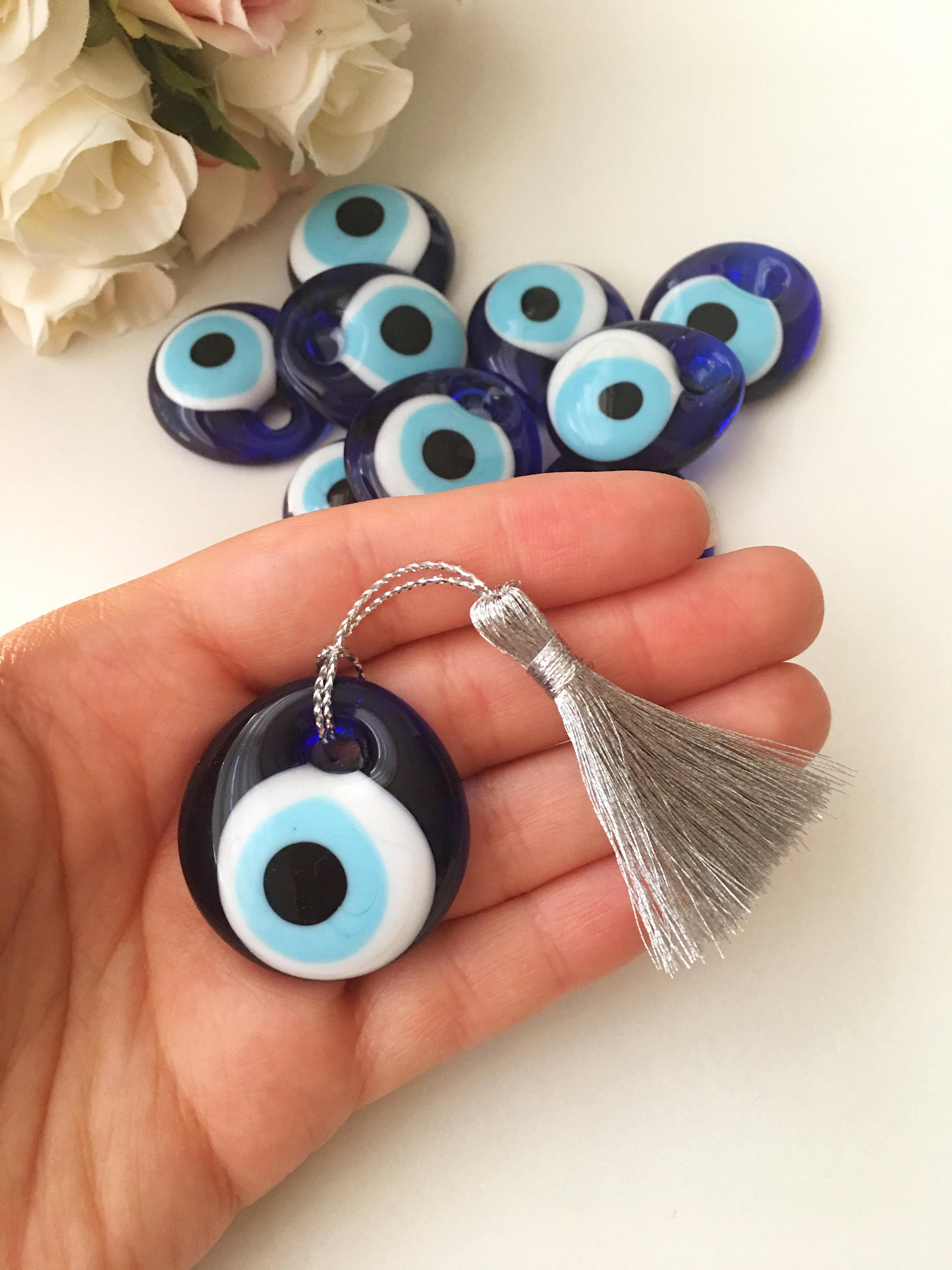 A collection of 50 blue glass evil eye beads with tassels, symbolizing protection and good luck, perfect for wedding favors.