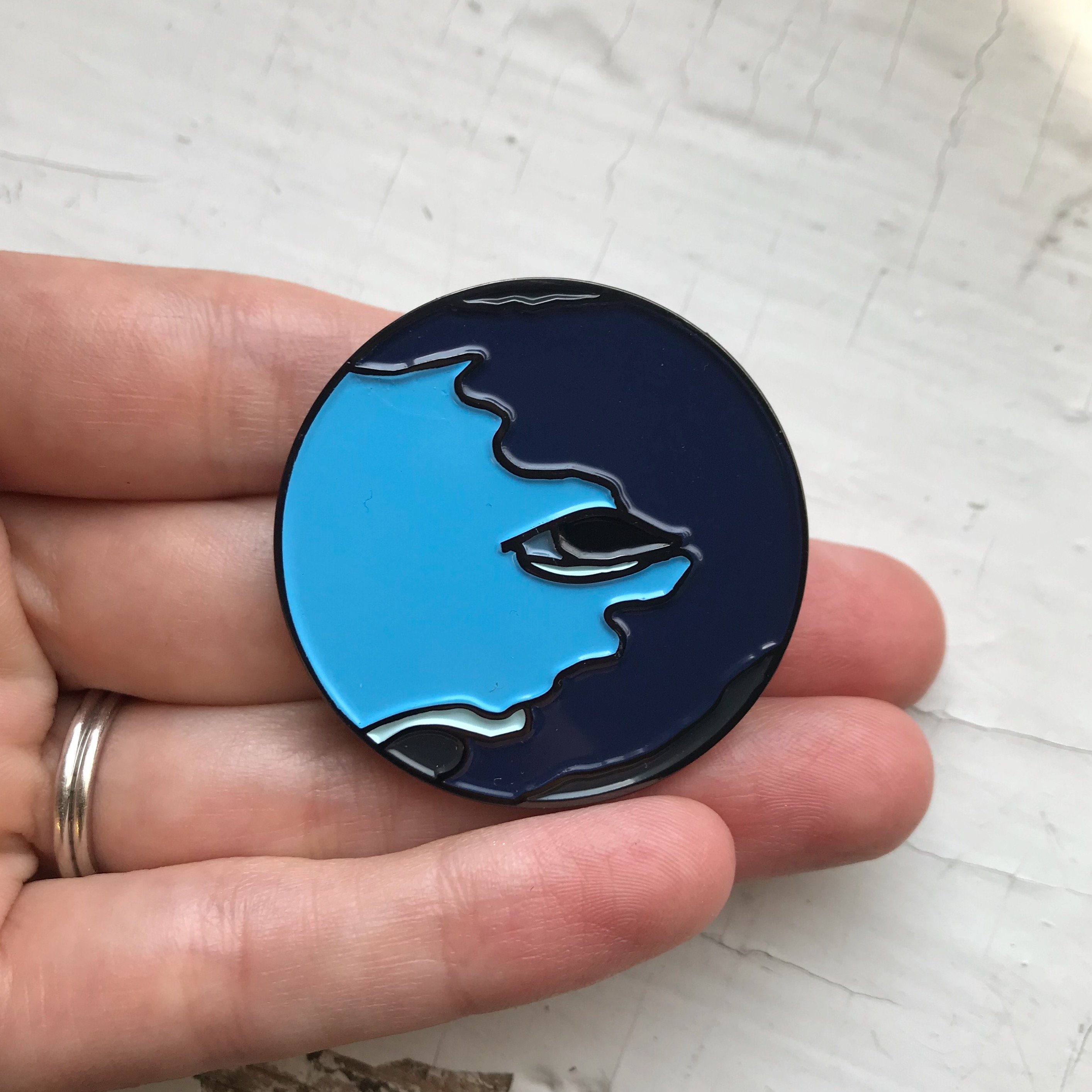 Neptune Enamel Pin featuring an original illustration by Lauren Beacham, showcasing vibrant colors and intricate details.