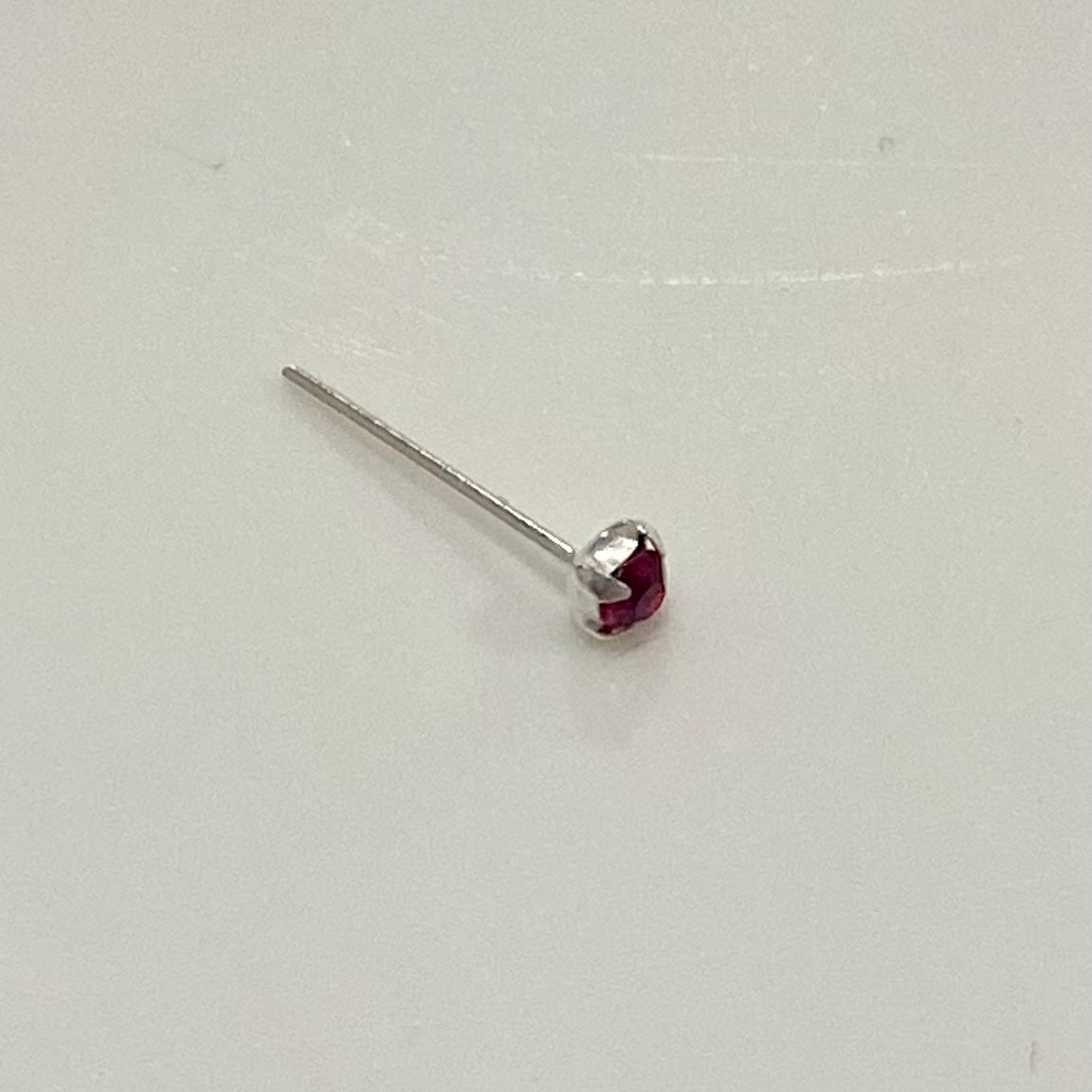 A beautiful Nose Pin with Gemstone in various colors, crafted from surgical steel, showcasing its adjustable design and elegant appearance.