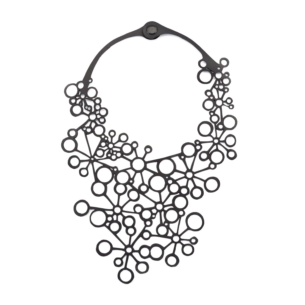 A handcrafted black statement necklace made from recycled inner tubes, featuring a unique circular design symbolizing the number eight.