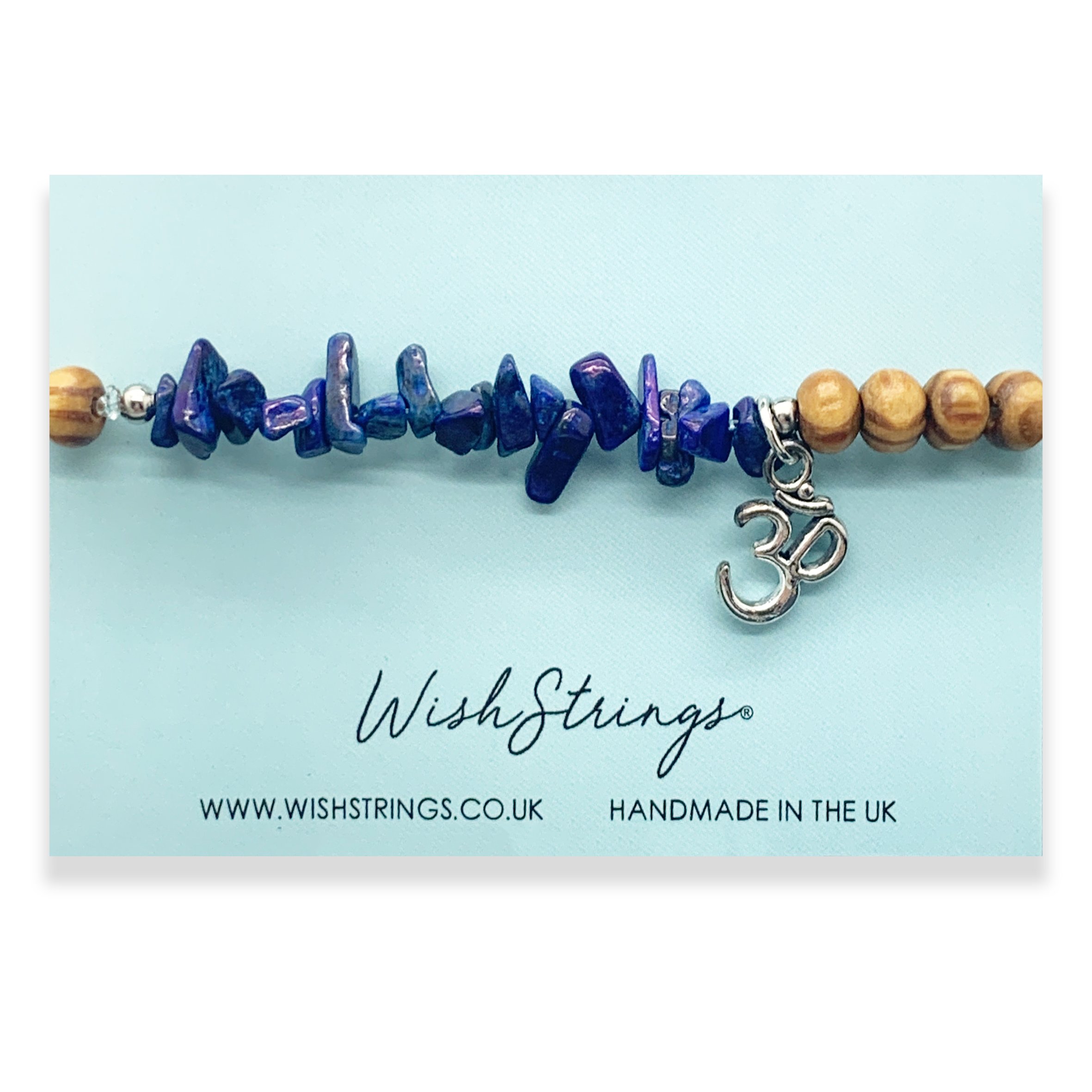 A beautifully crafted OHM GEMSTONE Charm Bracelet featuring Tibetan charms on a stretch elastic cord, presented on an inspirational packaging card.