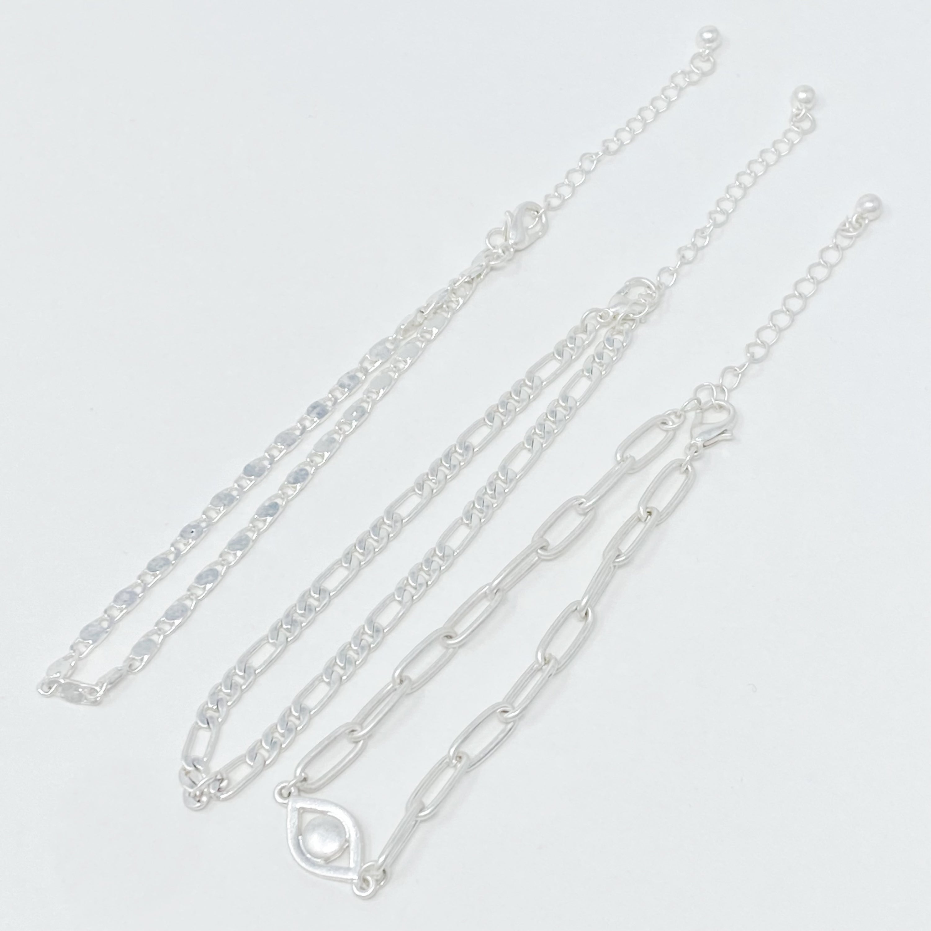 Set of three trendy chain anklets, featuring unique designs and adjustable lengths, perfect for layering or wearing alone.