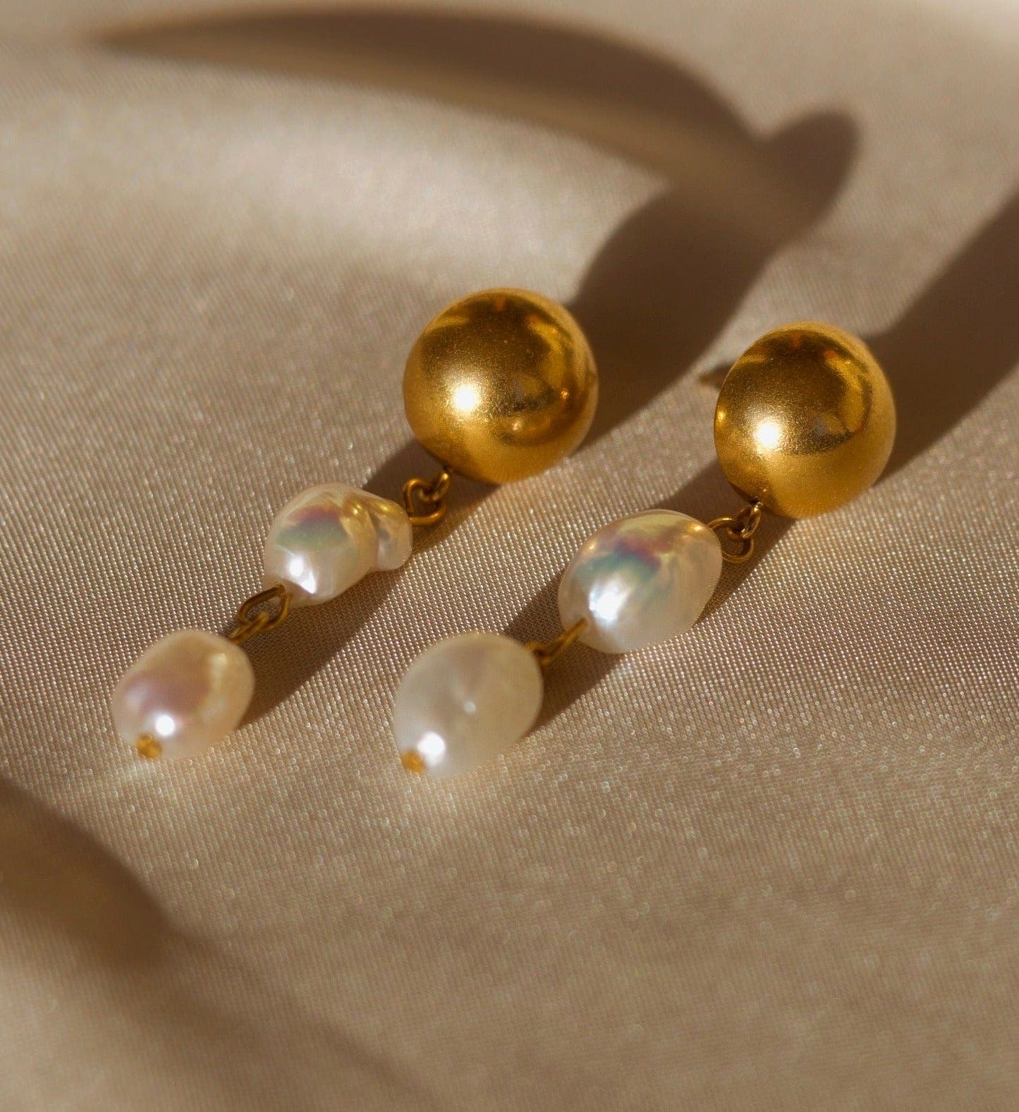 Elegant Orra - Long baroque pearl earrings with chunky stainless steel design and 18K gold plating.