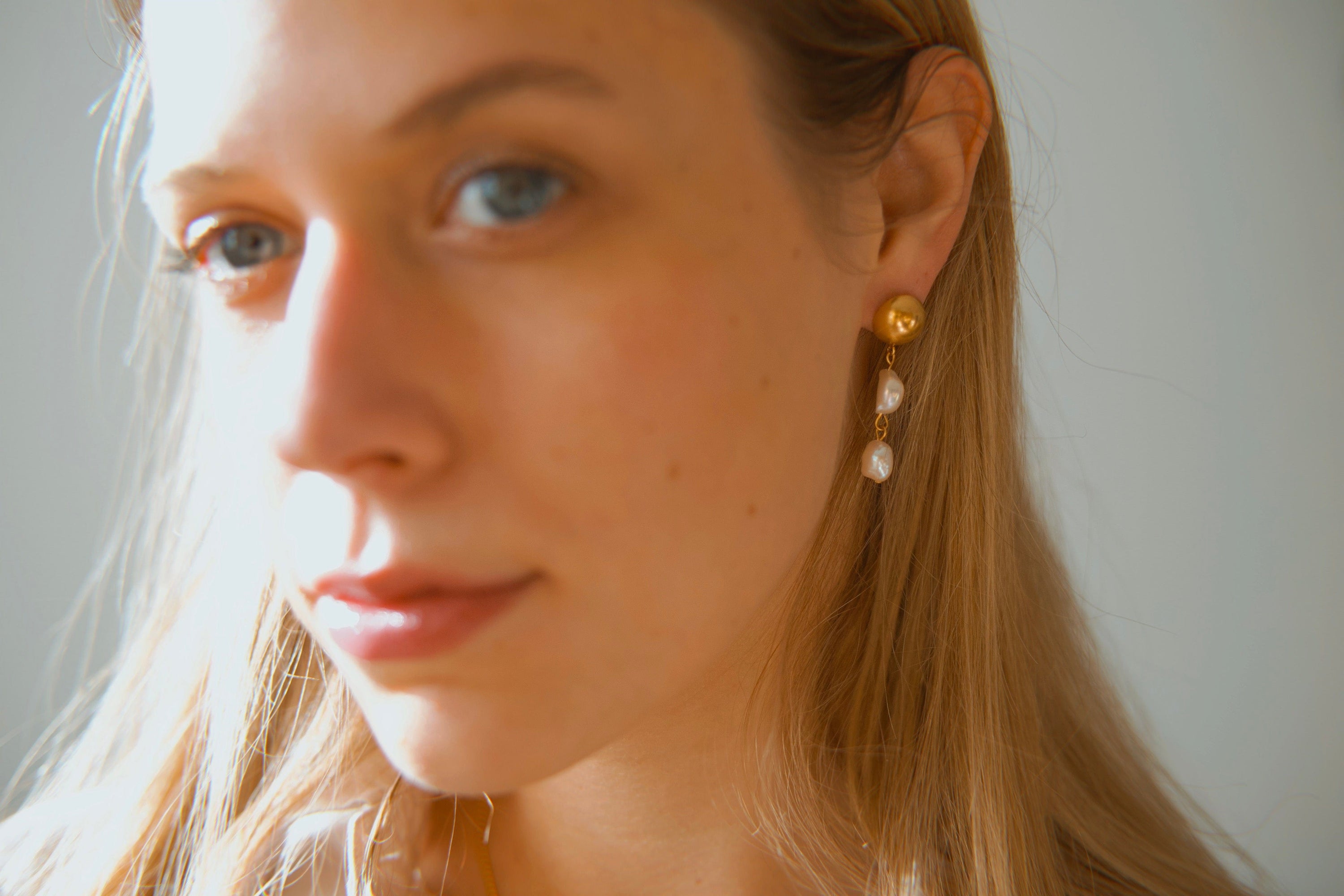 Elegant Orra - Long baroque pearl earrings with chunky stainless steel design and 18K gold plating.