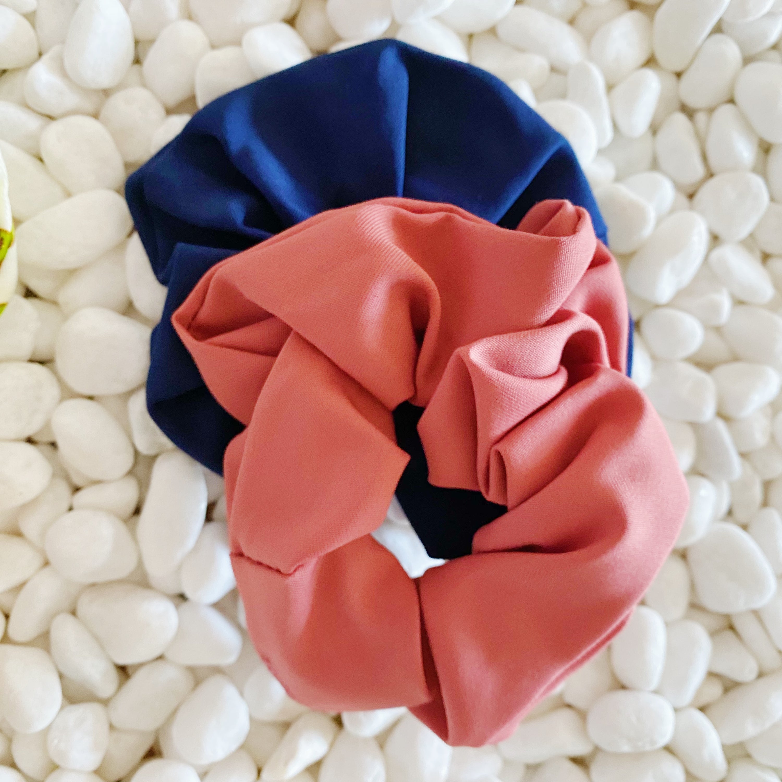 A set of four colorful hair scrunchies featuring two fruit prints and two solid colors, neatly arranged in a clear cello case.