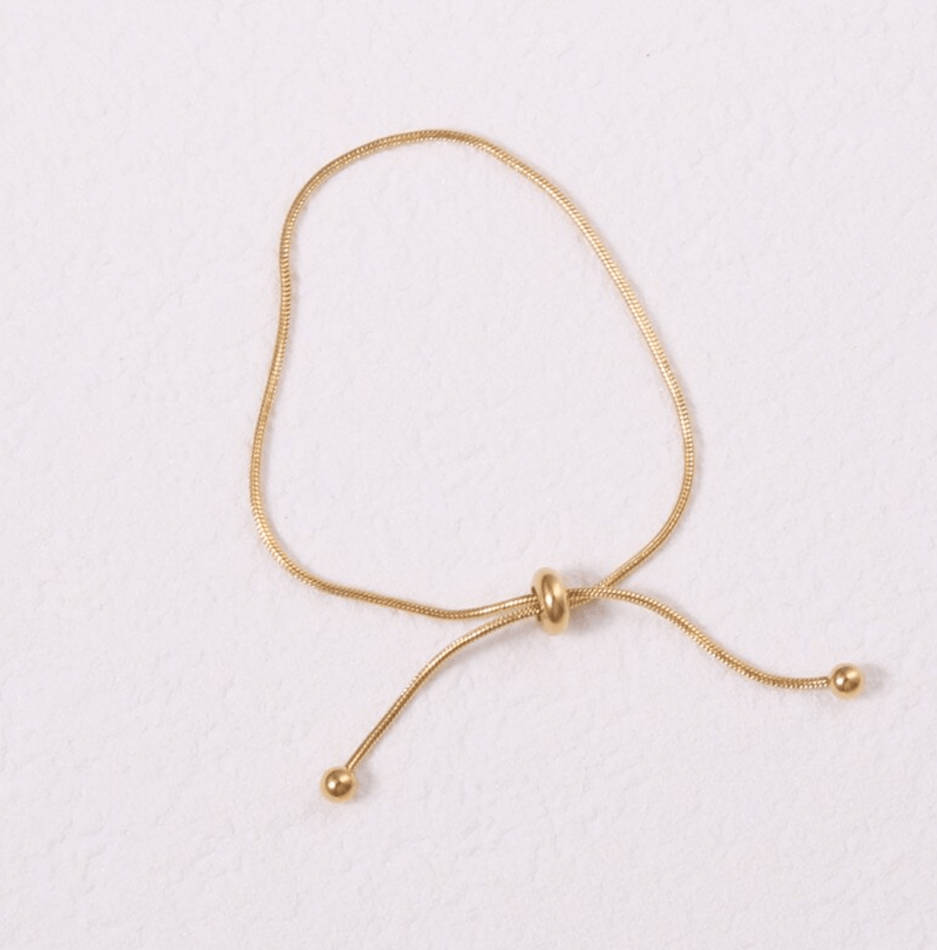 Orpheus Thin Gold Bracelet featuring a dainty snake chain design, adjustable length, and rich gold plating on stainless steel.