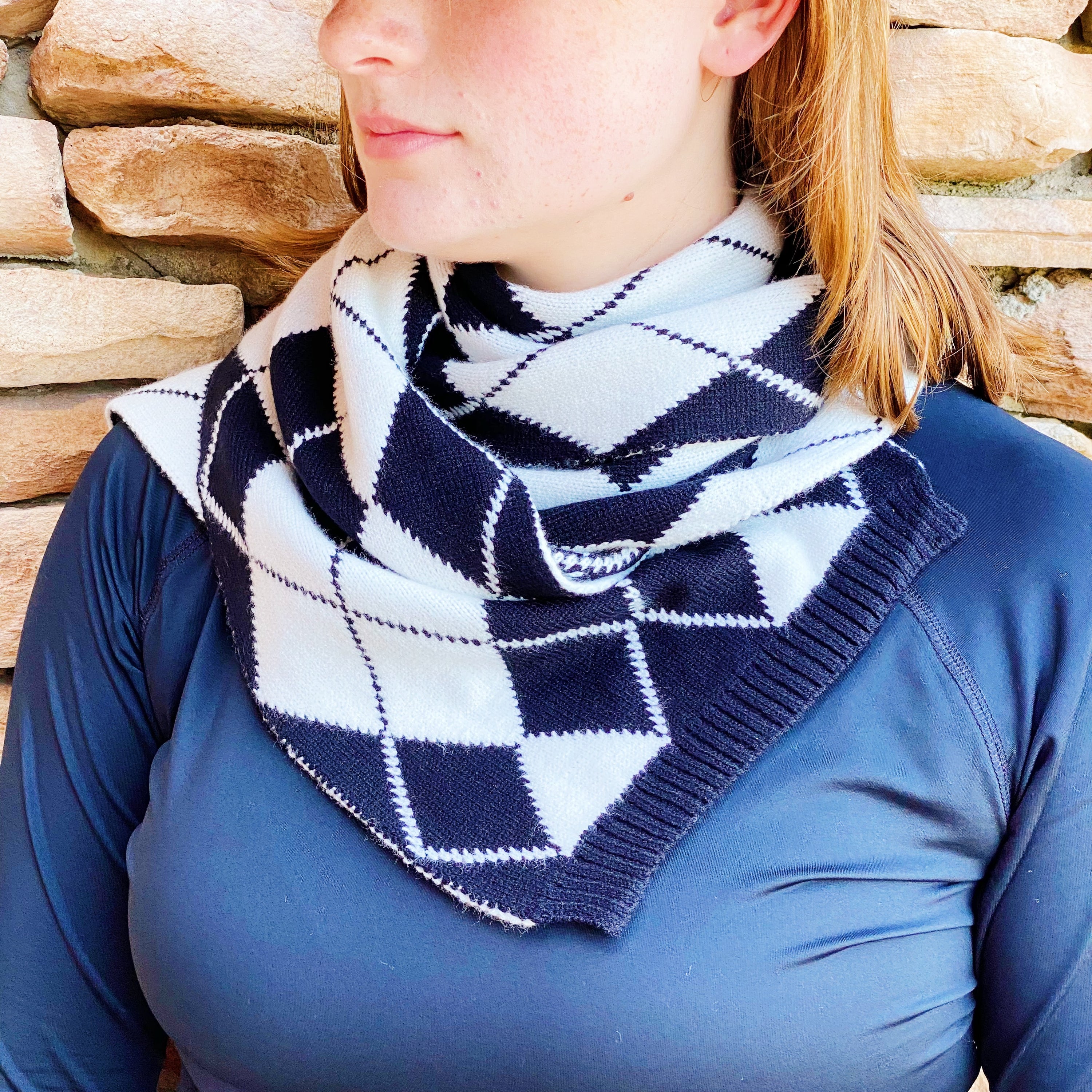 Cozy knit scarf featuring a classic argyle pattern, perfect for fall outfits, measuring 10 inches by 64 inches.