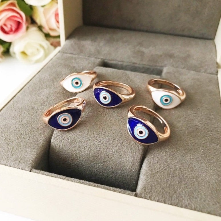 A beautiful adjustable Oval Evil Eye Ring featuring a blue or white evil eye bead set in a delicate rose gold design.