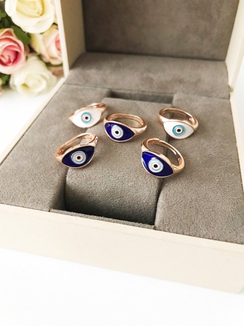 A beautiful adjustable Oval Evil Eye Ring featuring a blue or white evil eye bead set in a delicate rose gold design.