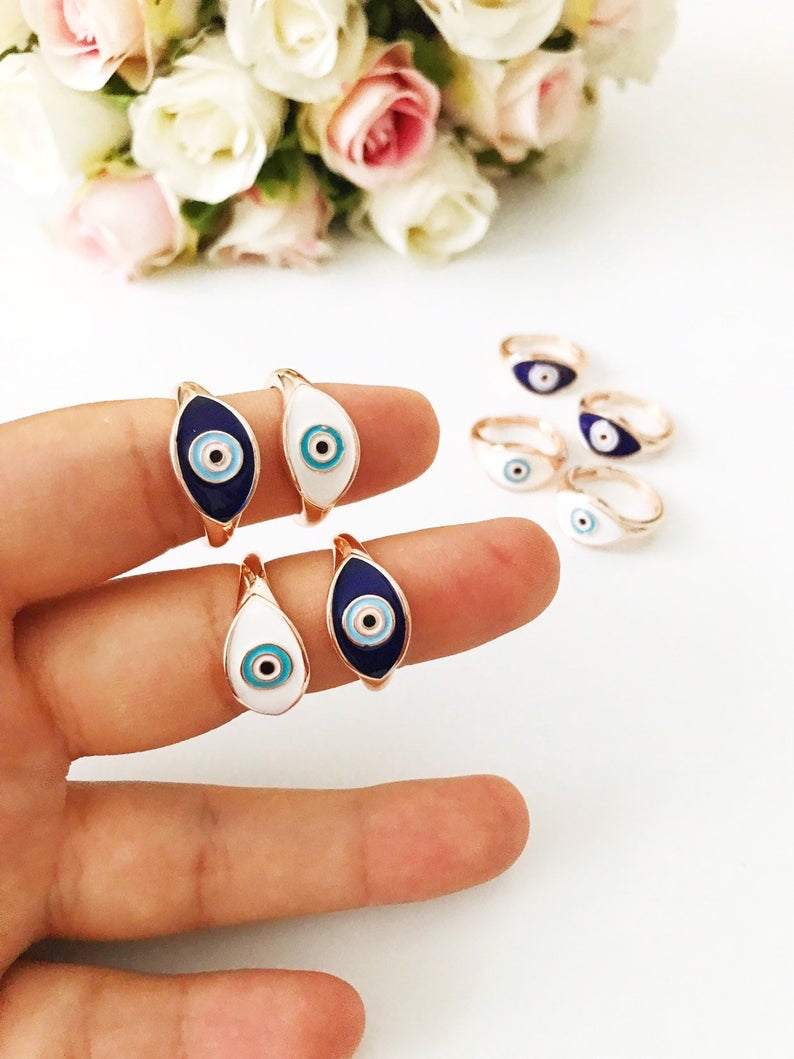 A beautiful adjustable Oval Evil Eye Ring featuring a blue or white evil eye bead set in a delicate rose gold design.