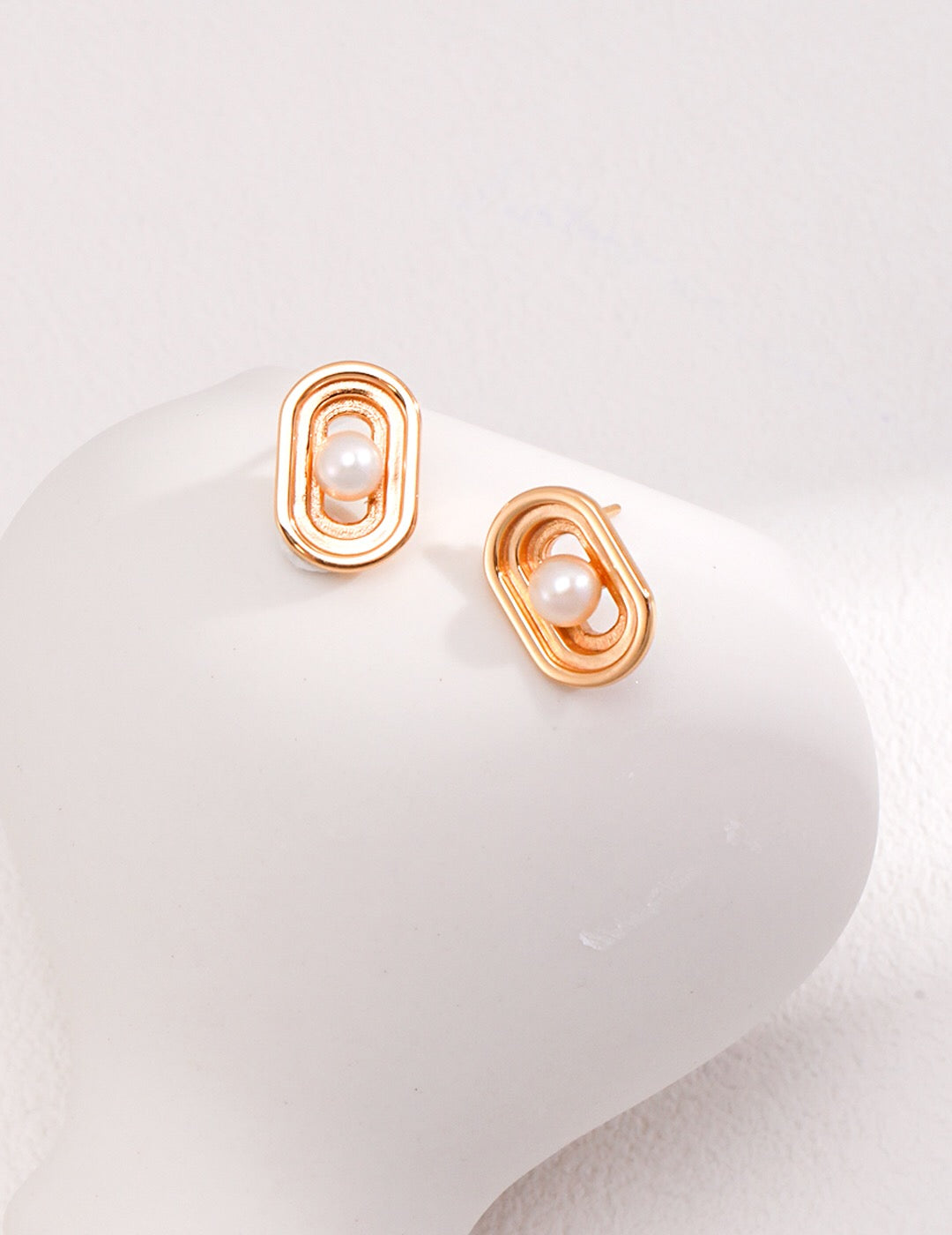 Elegant Oval Hollow Pearl Stud Earrings made from natural pearls and gold vermeil, showcasing a modern design.