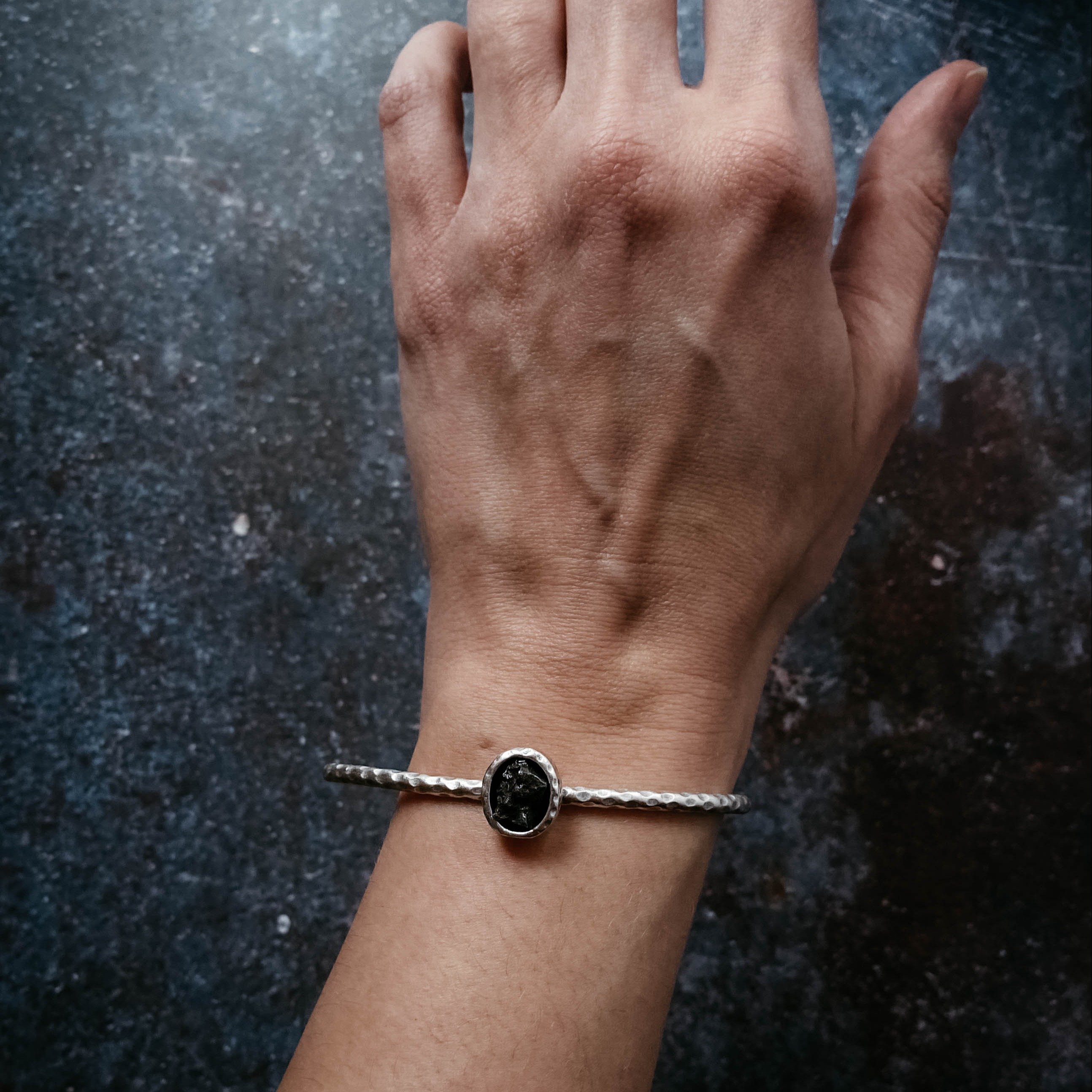 Oval Meteorite Cuff Bracelet featuring a raw Campo del Cielo meteorite set in a textured silver-tone cuff.