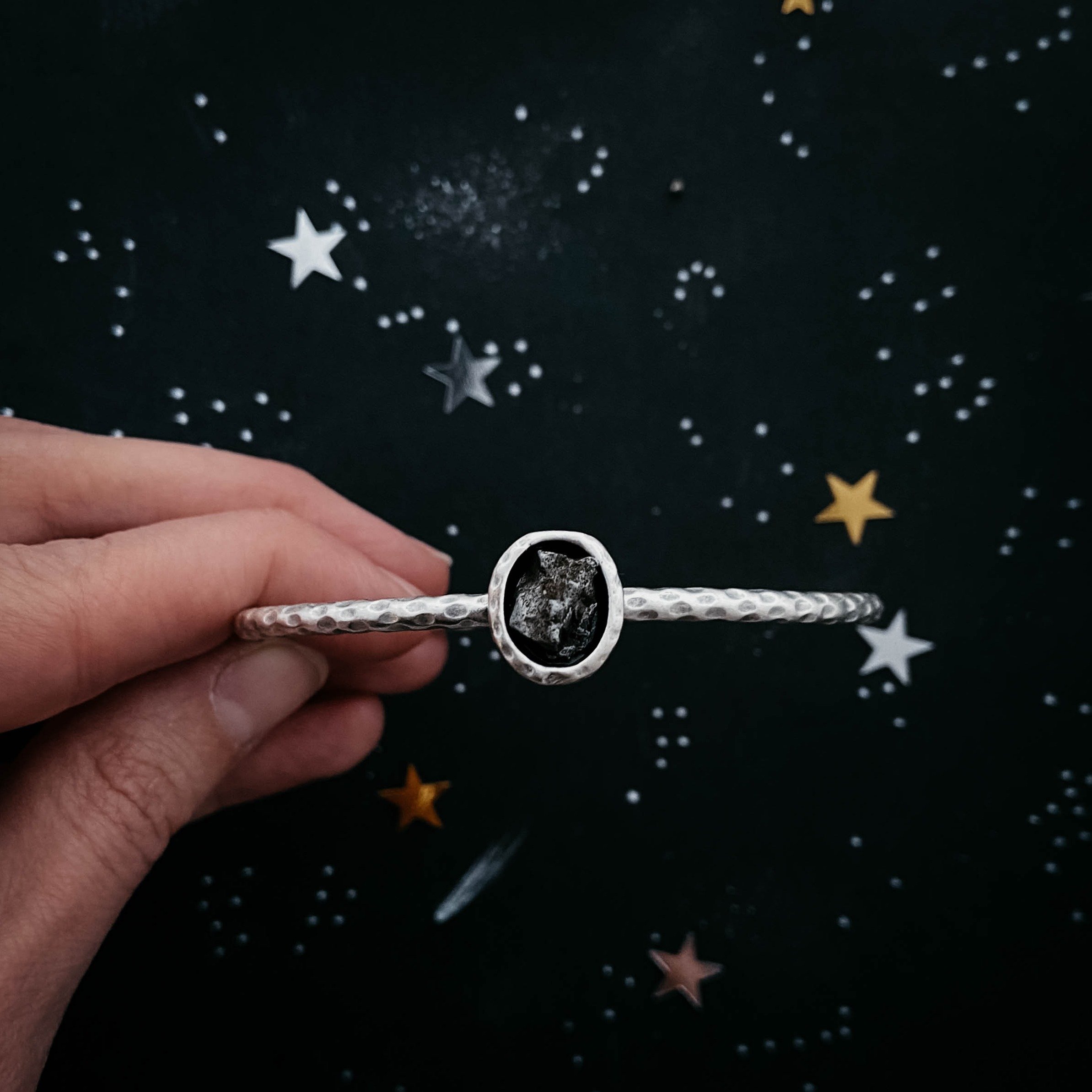 Oval Meteorite Cuff Bracelet featuring a raw Campo del Cielo meteorite set in a textured silver-tone cuff.