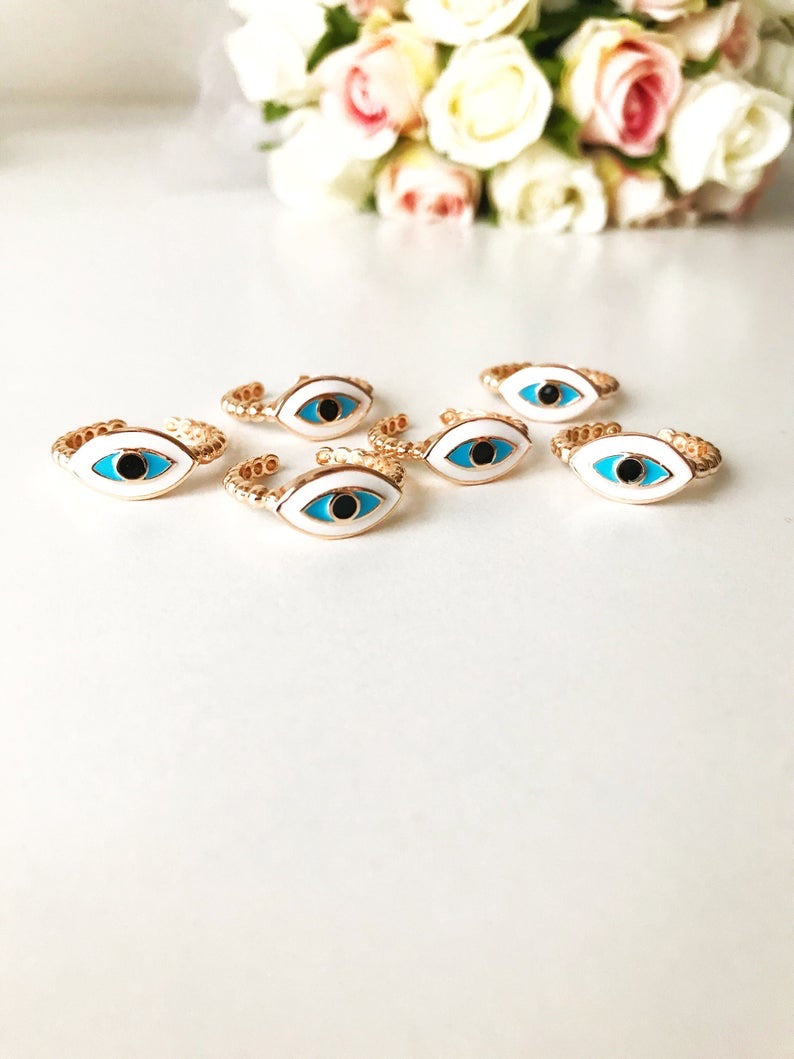 A stylish oval rose gold evil eye ring featuring a white evil eye bead, adjustable design for comfort, and minimalist elegance.