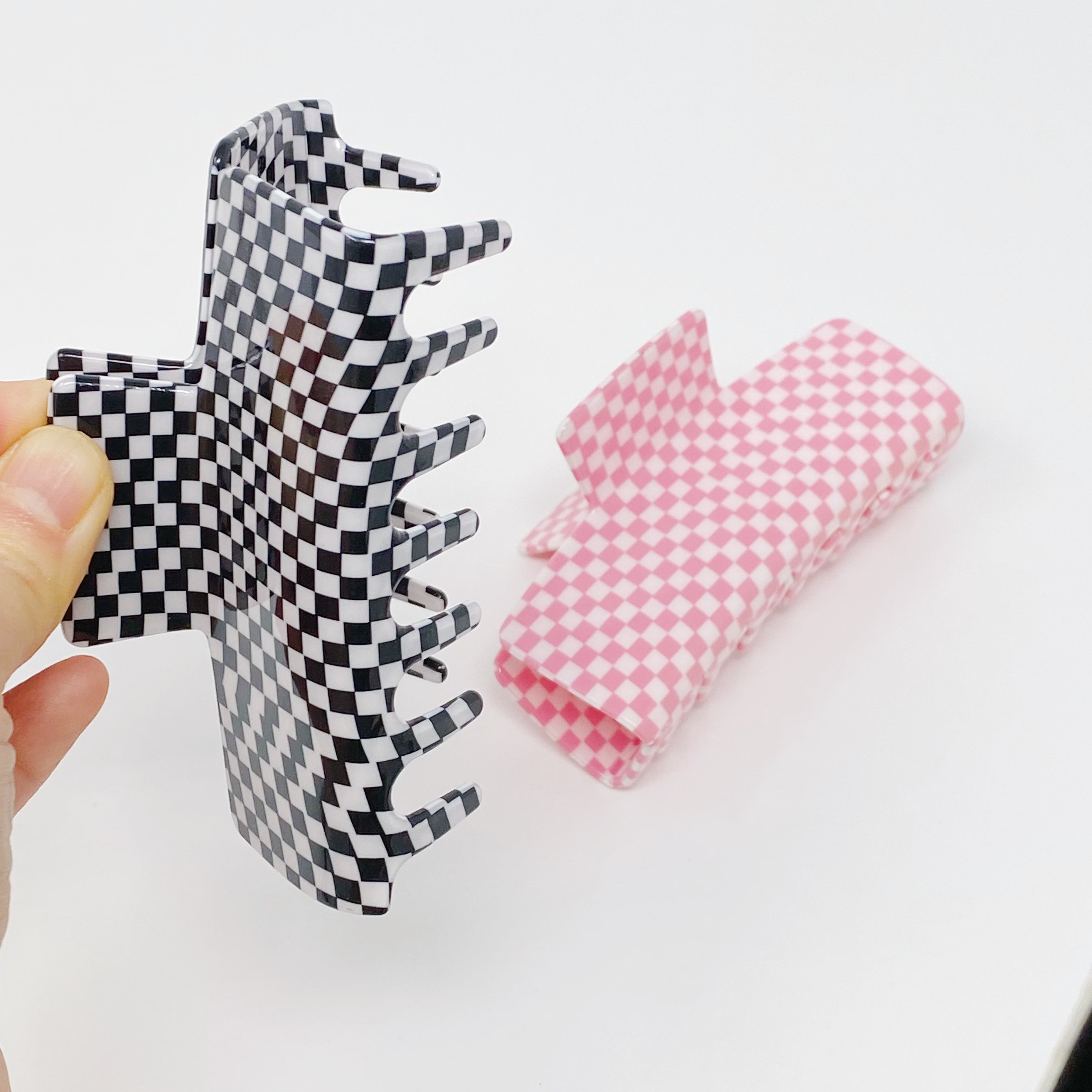 Oversized checkered hair claw clip in black and white pattern, designed for thick hair, measuring 4 inches by 2 inches.