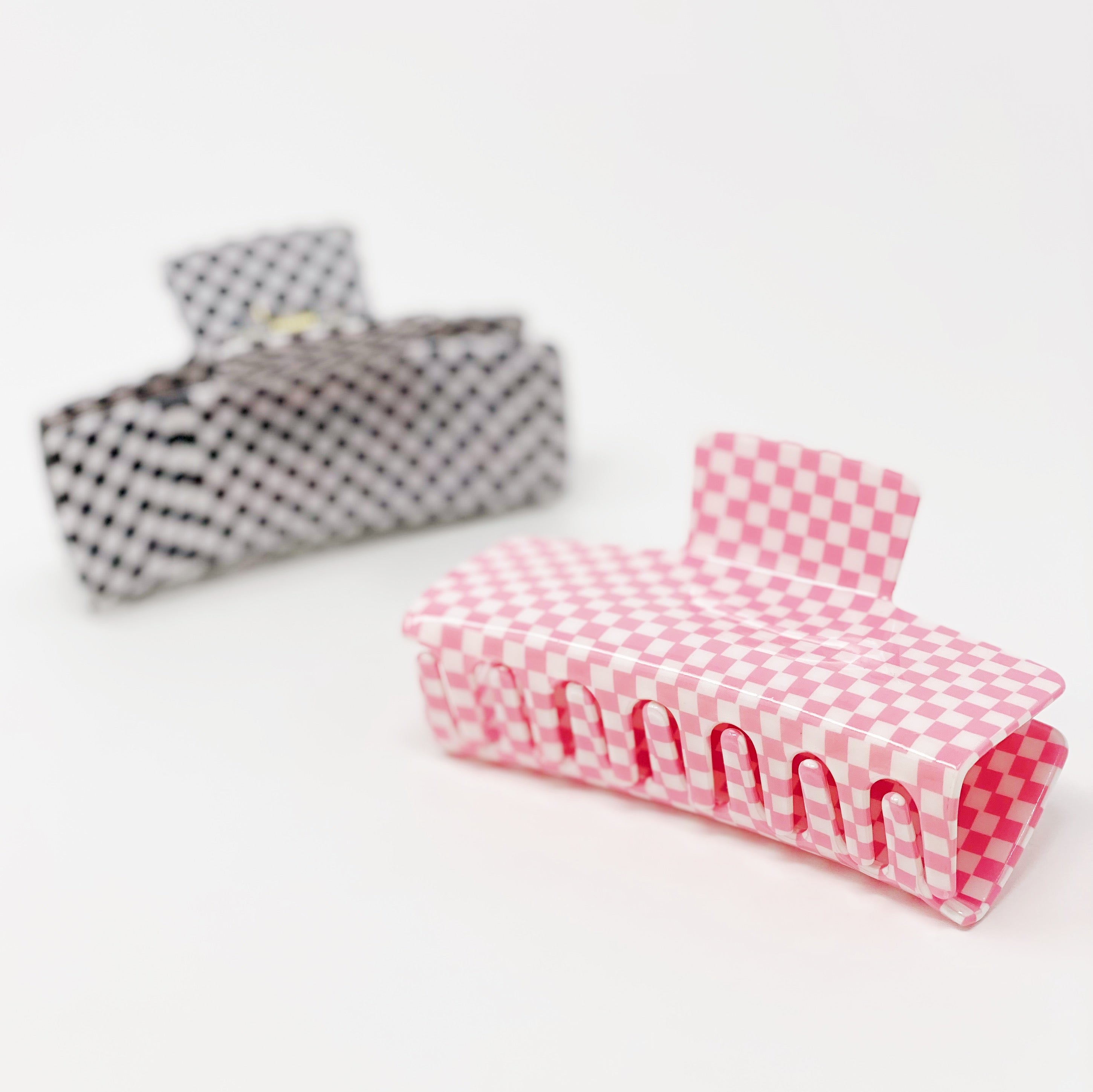 Oversized checkered hair claw clip in black and white pattern, designed for thick hair, measuring 4 inches by 2 inches.