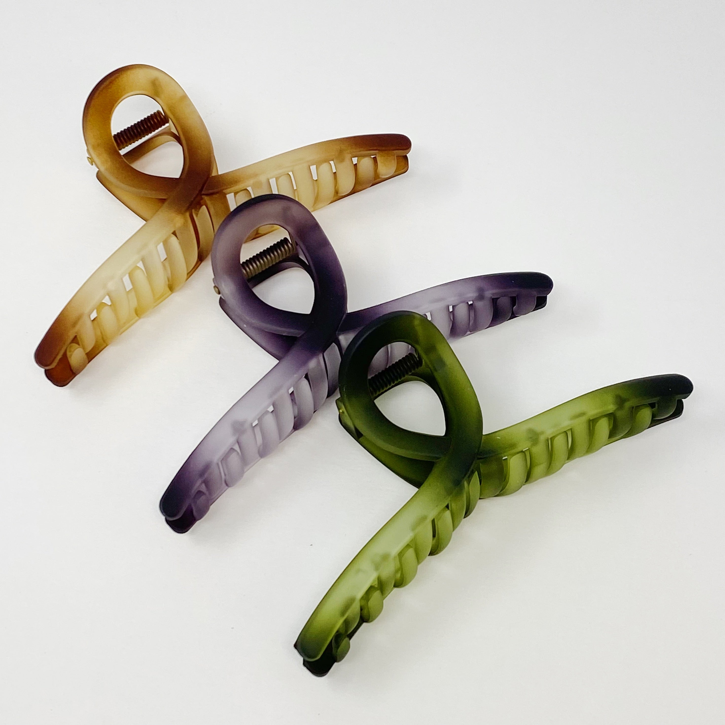 Set of three oversized hair claws in mystic ombre colors, elegantly displayed in a clear cello bag.