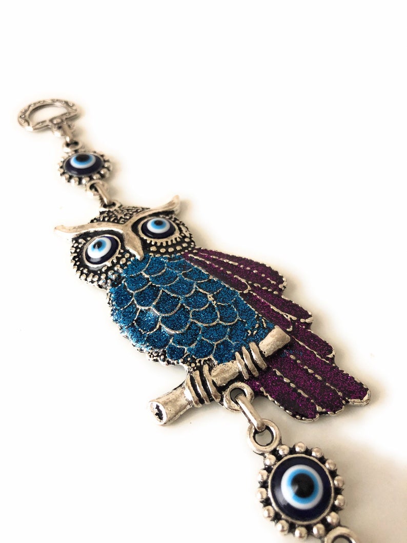 A beautifully crafted owl wall hanging featuring vibrant glass evil eyes, symbolizing protection and good luck, perfect for home decoration.