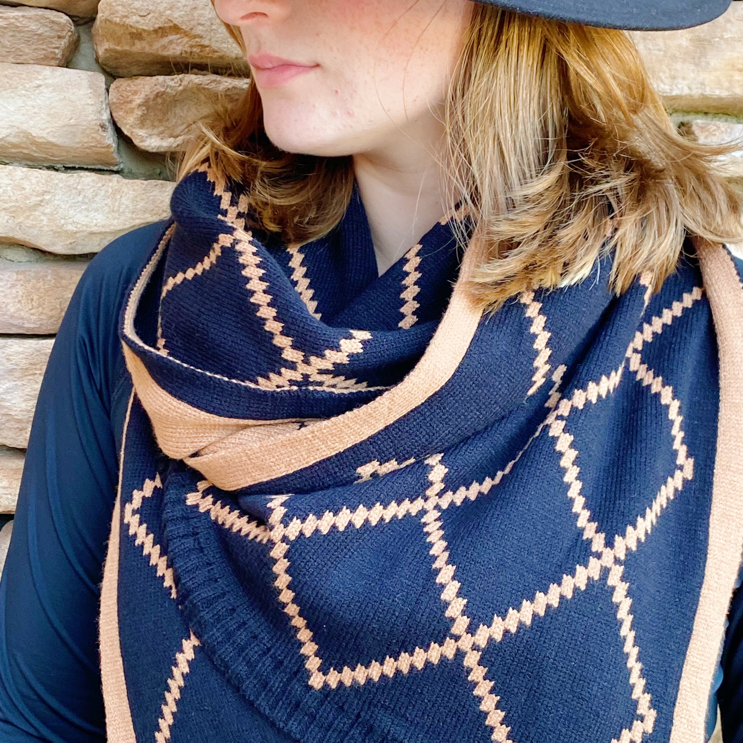 A cozy Paris Class Knit Scarf featuring a diamond pattern, showcasing its soft texture and reversible design in contrasting colors.